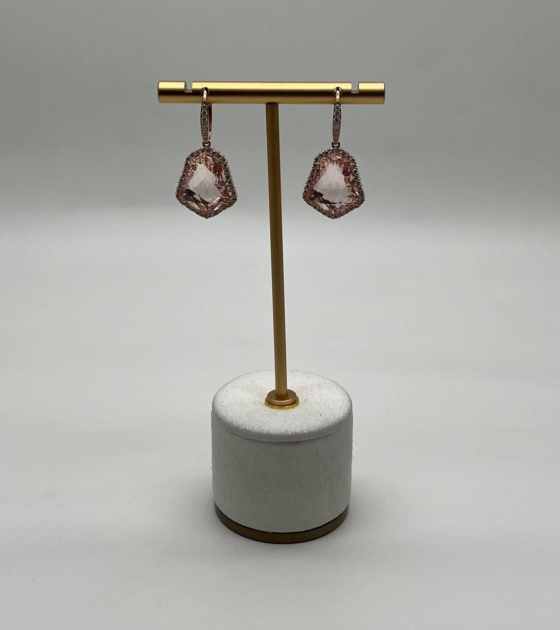 Discover the elegance of these exquisite earrings featuring a captivating design with faceted peach pink morganites, these earrings are a testament to modern craftsmanship.
The stones are encased in a delicate halo of accented diamonds, adding a