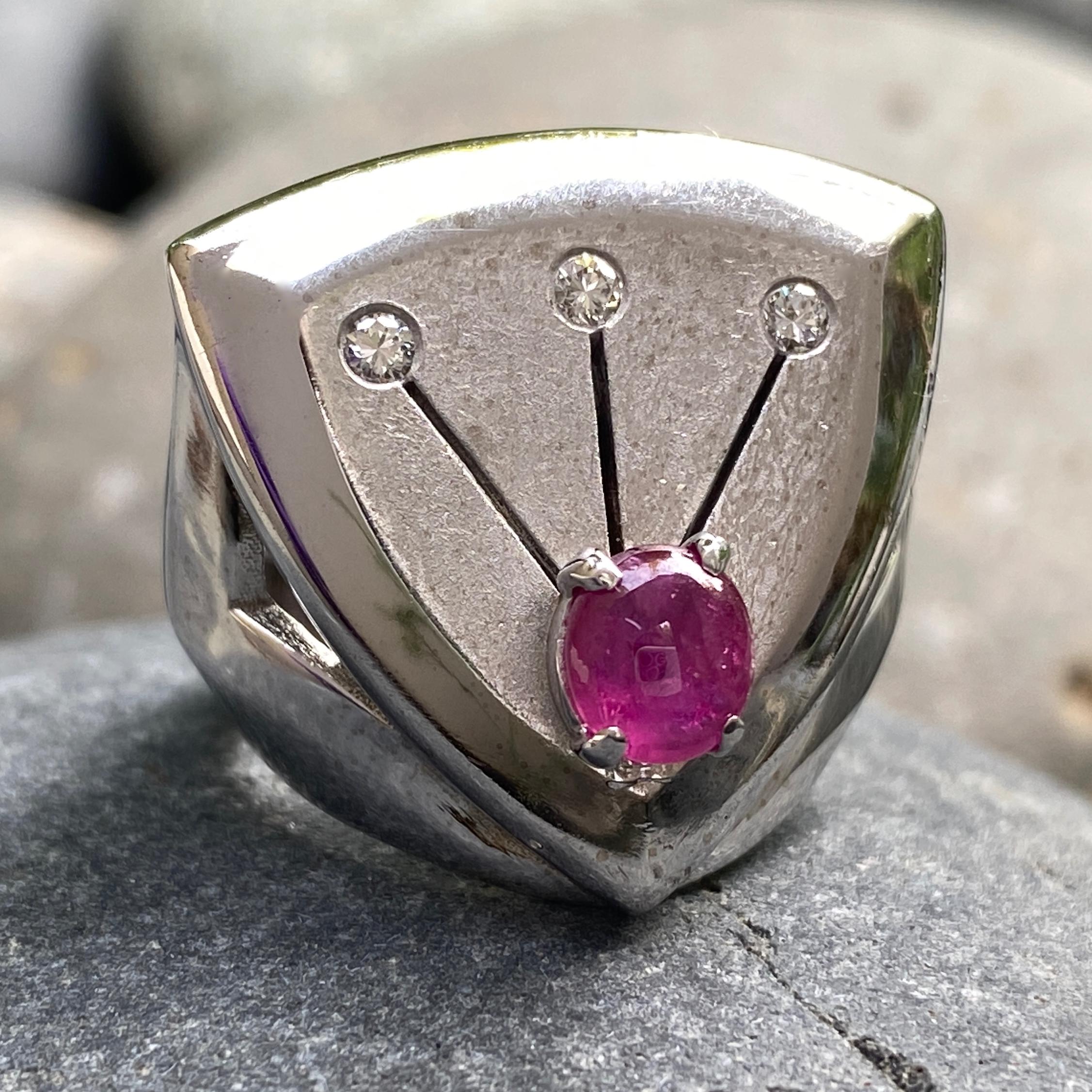 The face of this bold, modern ring started off in life as a cufflink,* probably made in the early 1970s.

Originally set with a not-aging-very-well black star sapphire, Eytan replaced it with a nice 1.02 carat natural ruby cabochon.  The diamonds