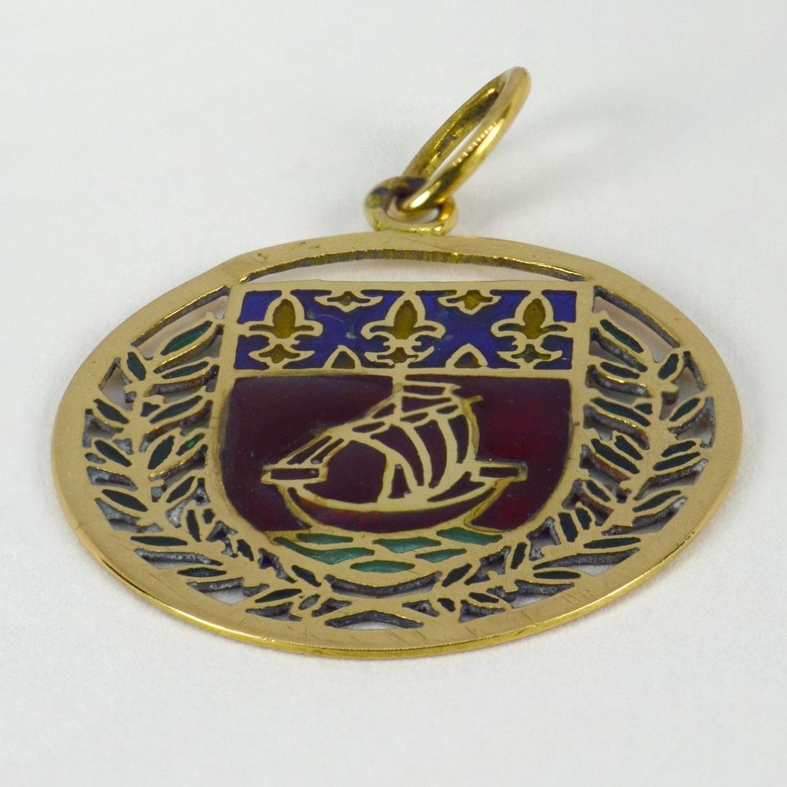 An 18 karat (18K) yellow gold charm pendant designed as a shield designed as the coat of arms for the City of Paris, depicting a yacht or boat in full sail surrounded by a laurel wreath, enhanced by plique-a-jour enamel work. Stamped with the