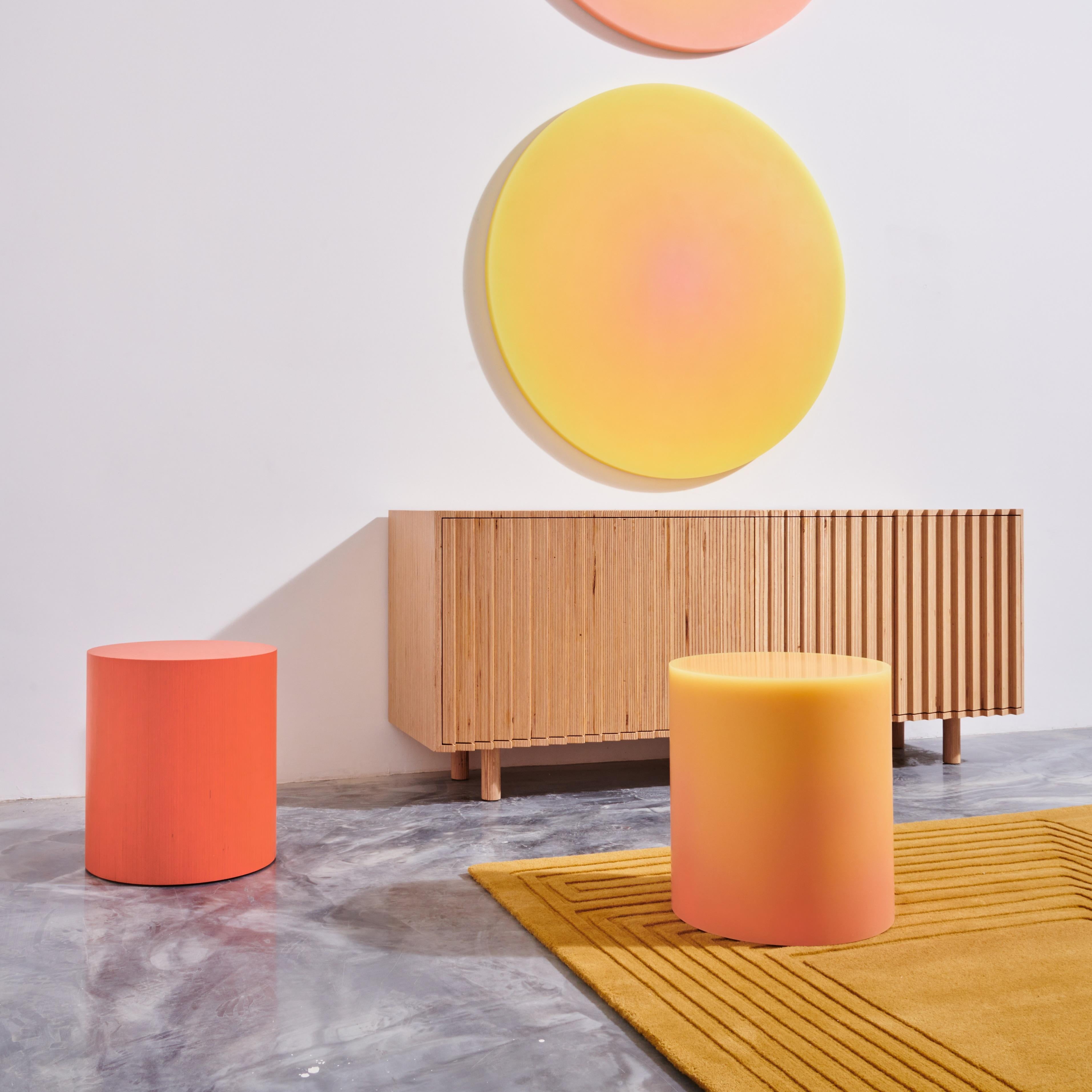 Resin stool in a warm colorway, featuring a matte exterior that generates a mesmerizing visual effect from a medley of gradual saturation shifts along the wavy patterns. The combination of core and resin color determines the overall hue variants of