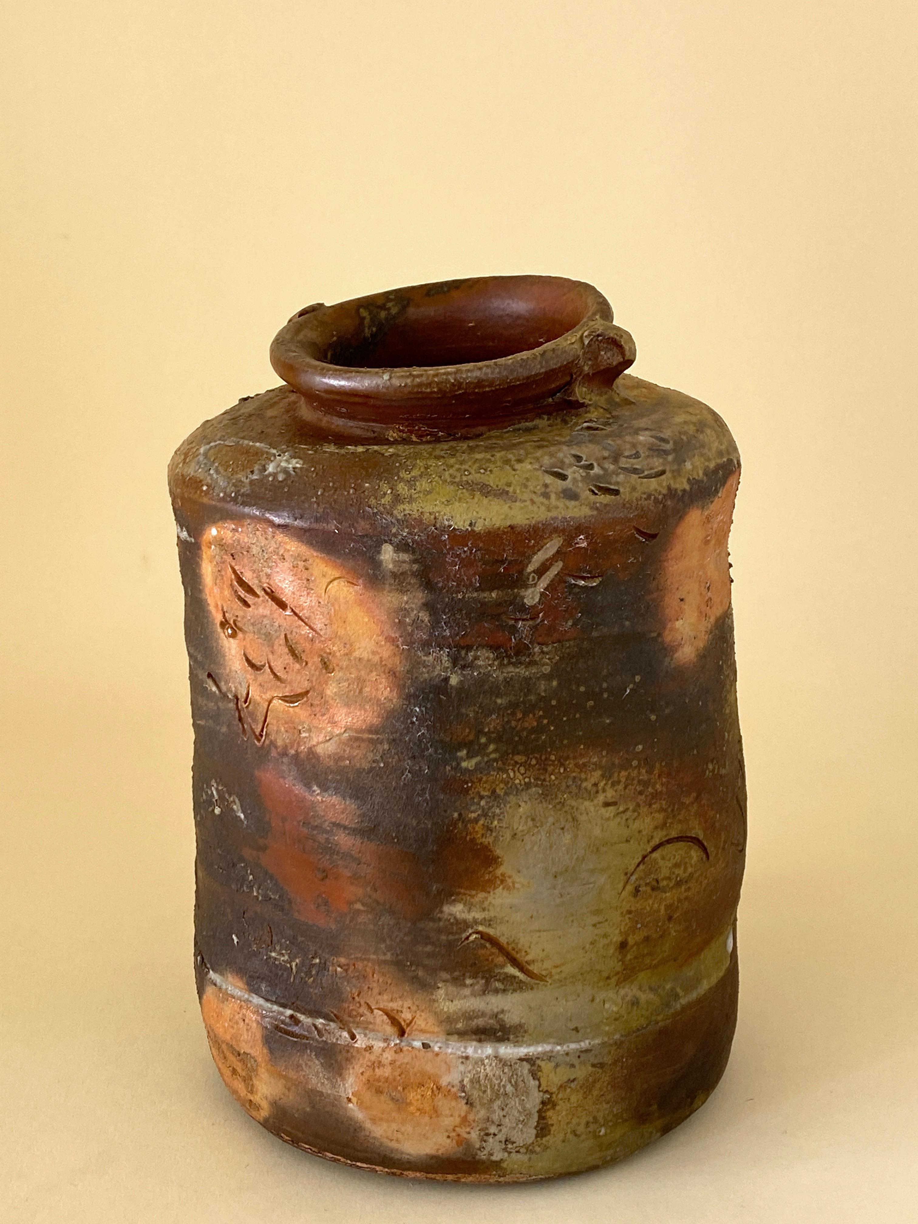 This gorgeous, noble ceramic jar was fired in a wood kiln and displays marks of all five elements in its creation - earth and water before firing, air and fire in the wood kiln, and metal where the minerals in the wood ash have hardened to a hard