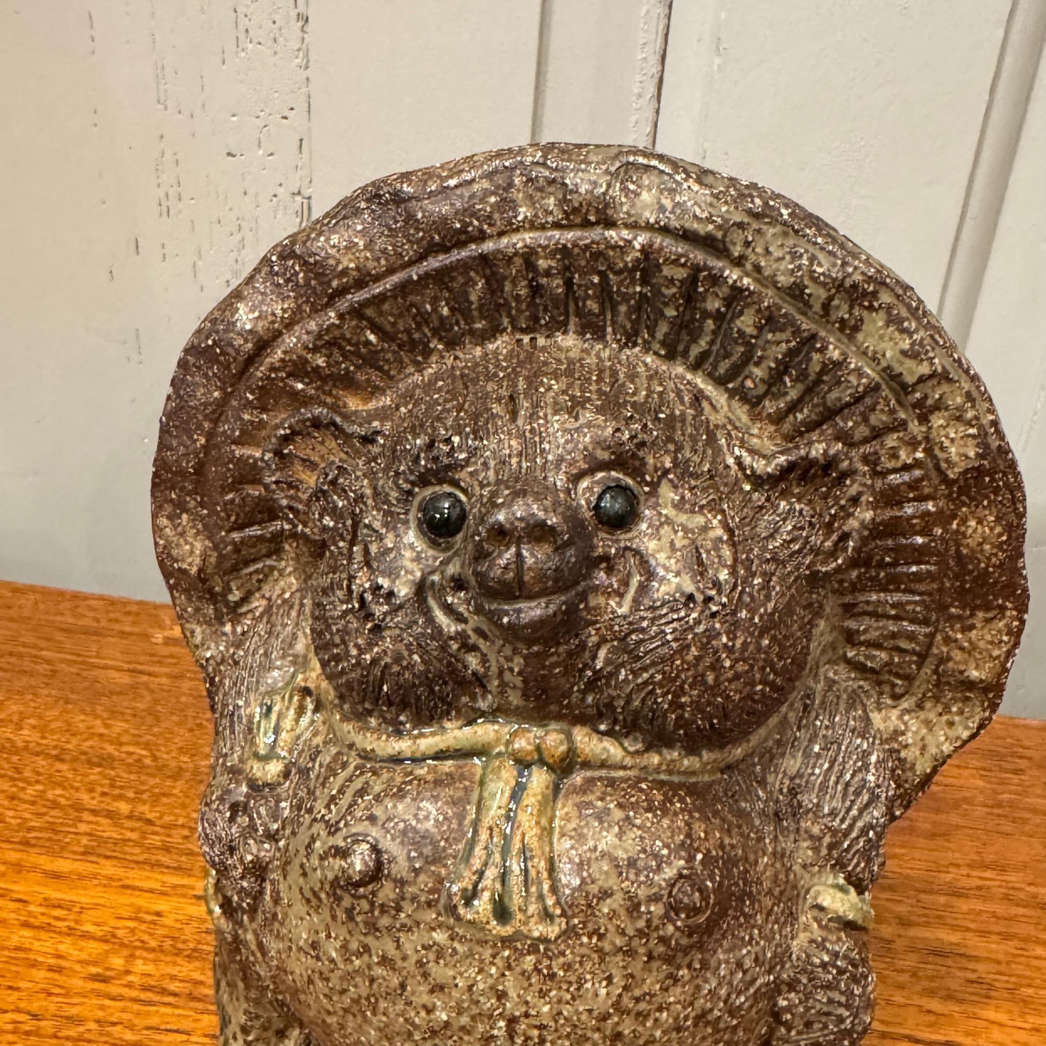 Il Tanuki Shigaraki, un'amata icona del folklore giapponese, è un portafortuna realizzato con maestria e proveniente da Shigaraki, una delle regioni più rinomate del Giappone per la lavorazione della ceramica. Questa stravagante rappresentazione del
