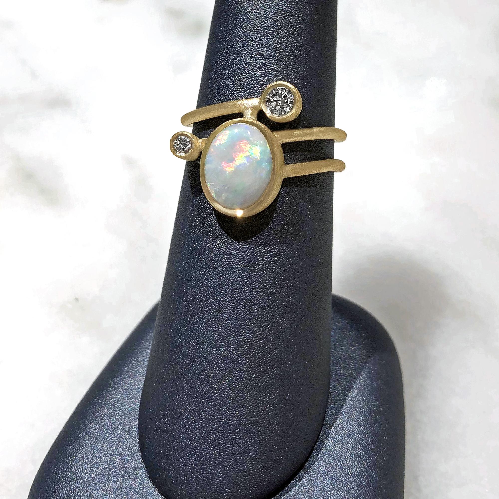 One of a Kind Gamma Ellipse Ring handcrafted in London by jewelry maker Shimell and Madden in beautifully textured 18k yellow gold featuring an oval australian white opal and accented with two round brilliant cut white diamonds totaling 0.22 carats.
