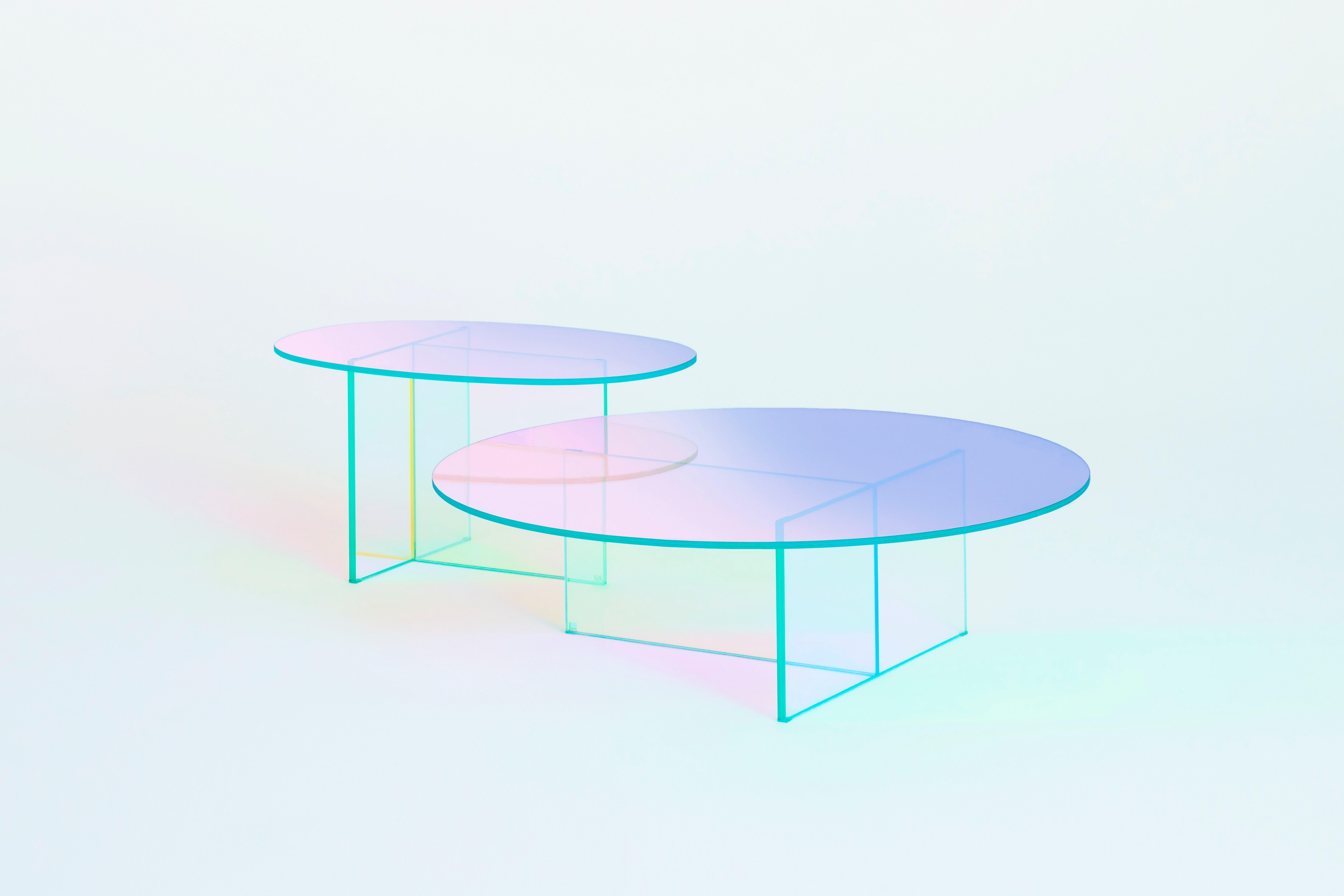 Tables hautes, tables basses et consoles en verre laminé et collé, caractérisées par une finition spéciale multichromatique irisée ; la nuance varie en fonction de l'angle de la source lumineuse et du point de vue. 
Disponible en verre transparent