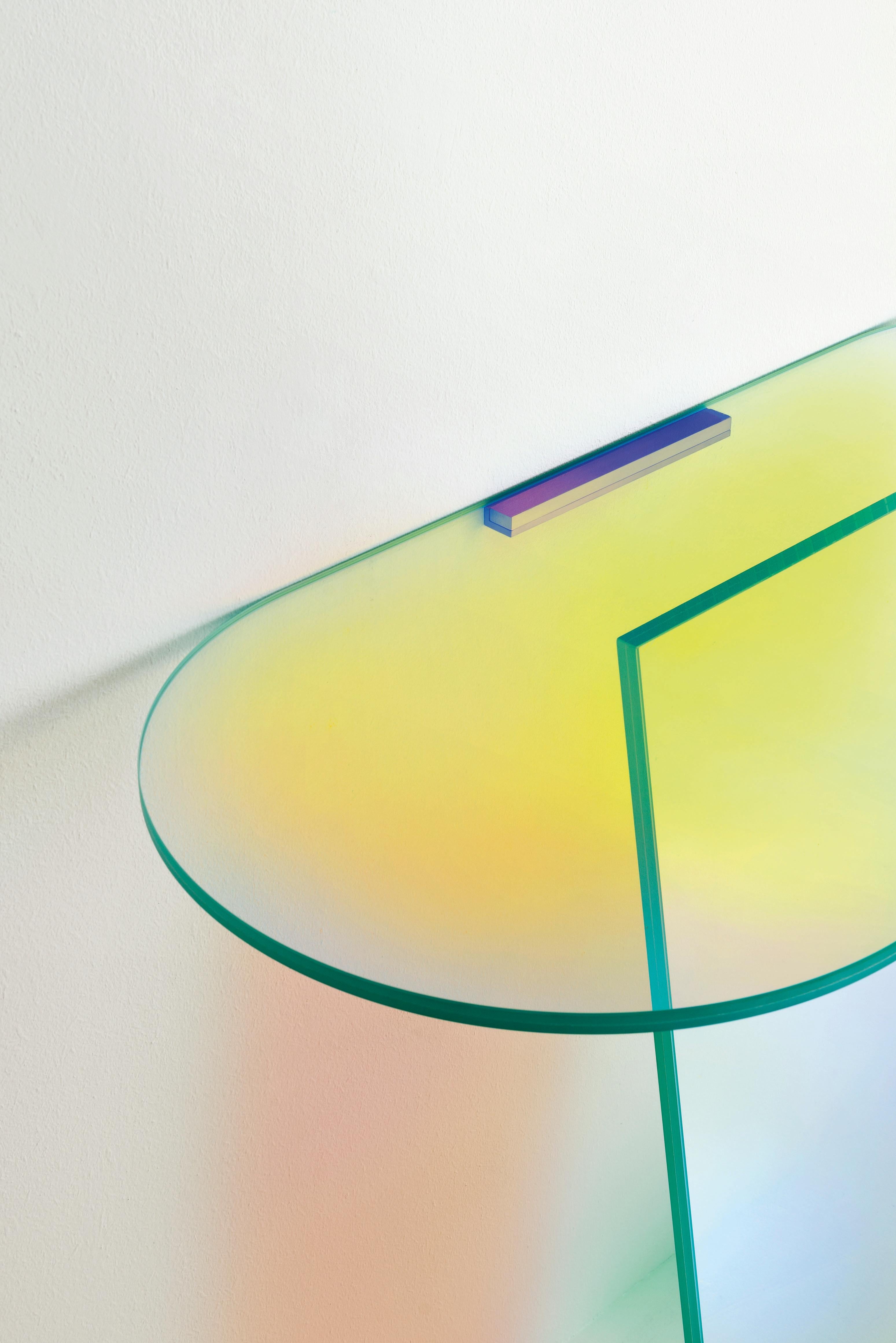 Shimmer console table is shown here in the laminated and glued glass. The collection is available in high tables, low tables and consoles in laminated and glued glass, characterized by a special iridescent multichromatic finish; the nuance varies