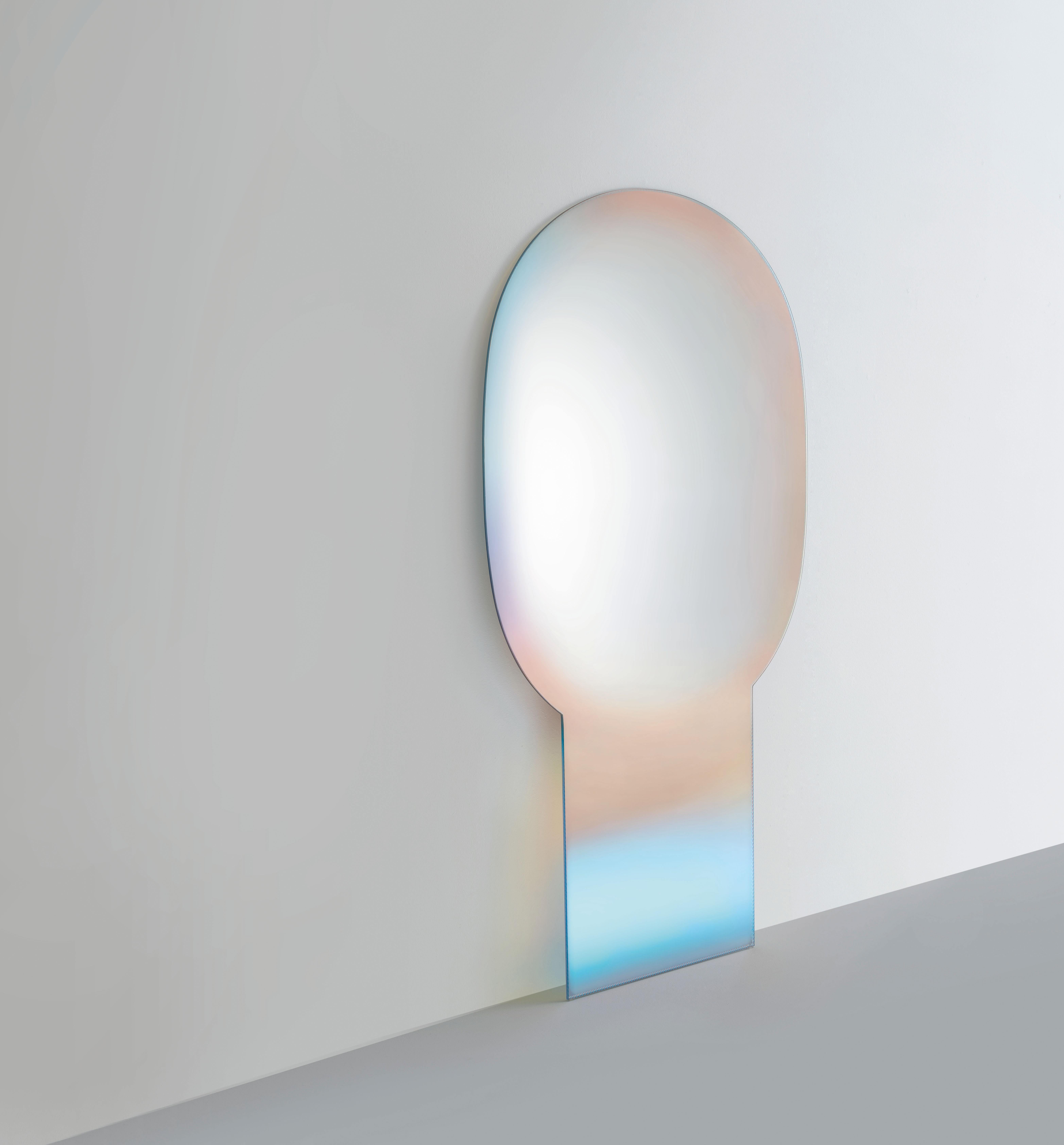 Shimmer Specchi mirror is shown here in the extralight glass. A series of mirrors in extralight glass. Made with refined processing techniques, a degrading shaded silvering mix and the magnificent iridescent multichromatic finish, a feature of the