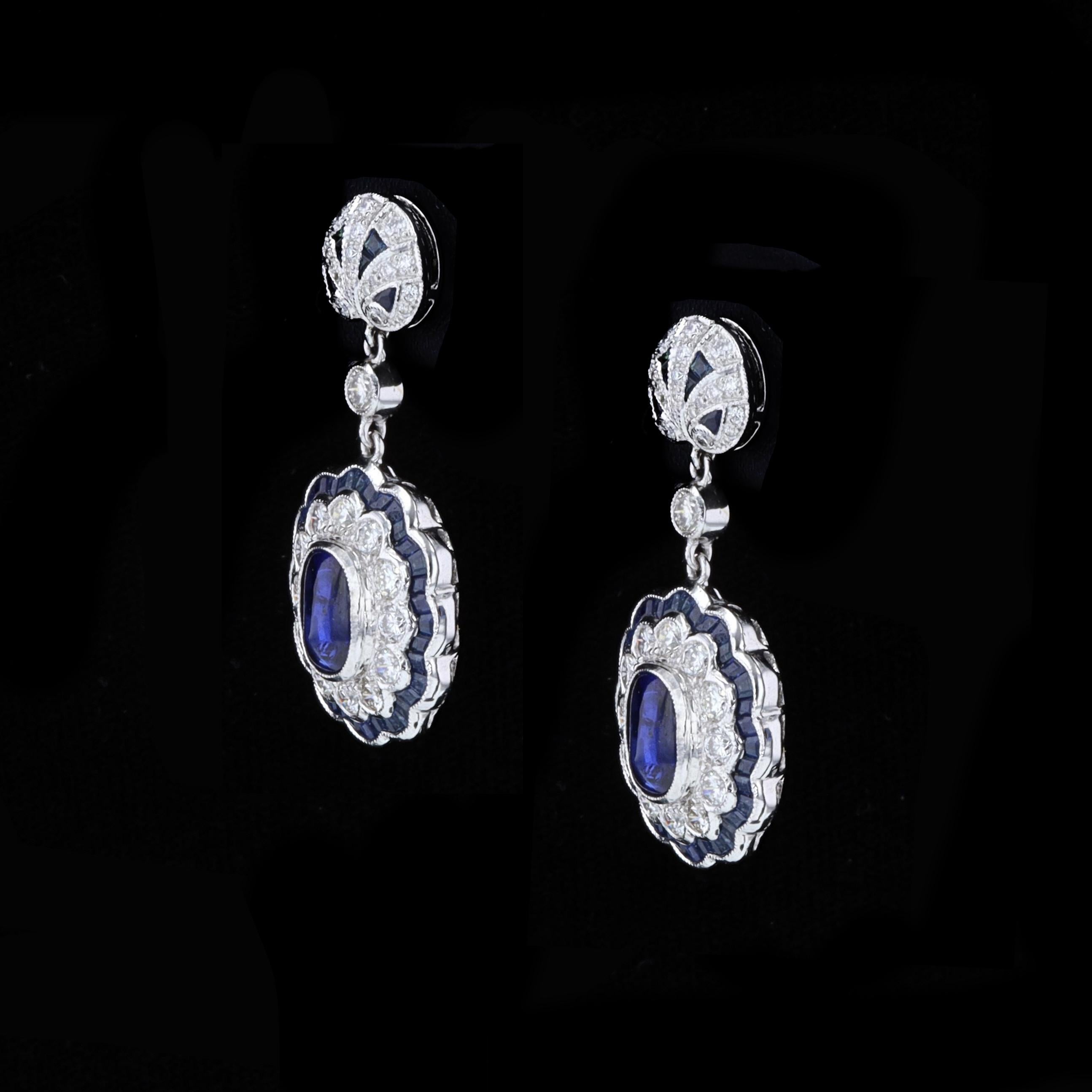 The earrings feature lovely sugarloaf cut sapphires that weigh approximately 3.17ct. The sapphires are accentuated by sparkling round cut diamonds that weigh approximately 2.33ct. The color of these diamonds is G-H with VS clarity. The earrings are