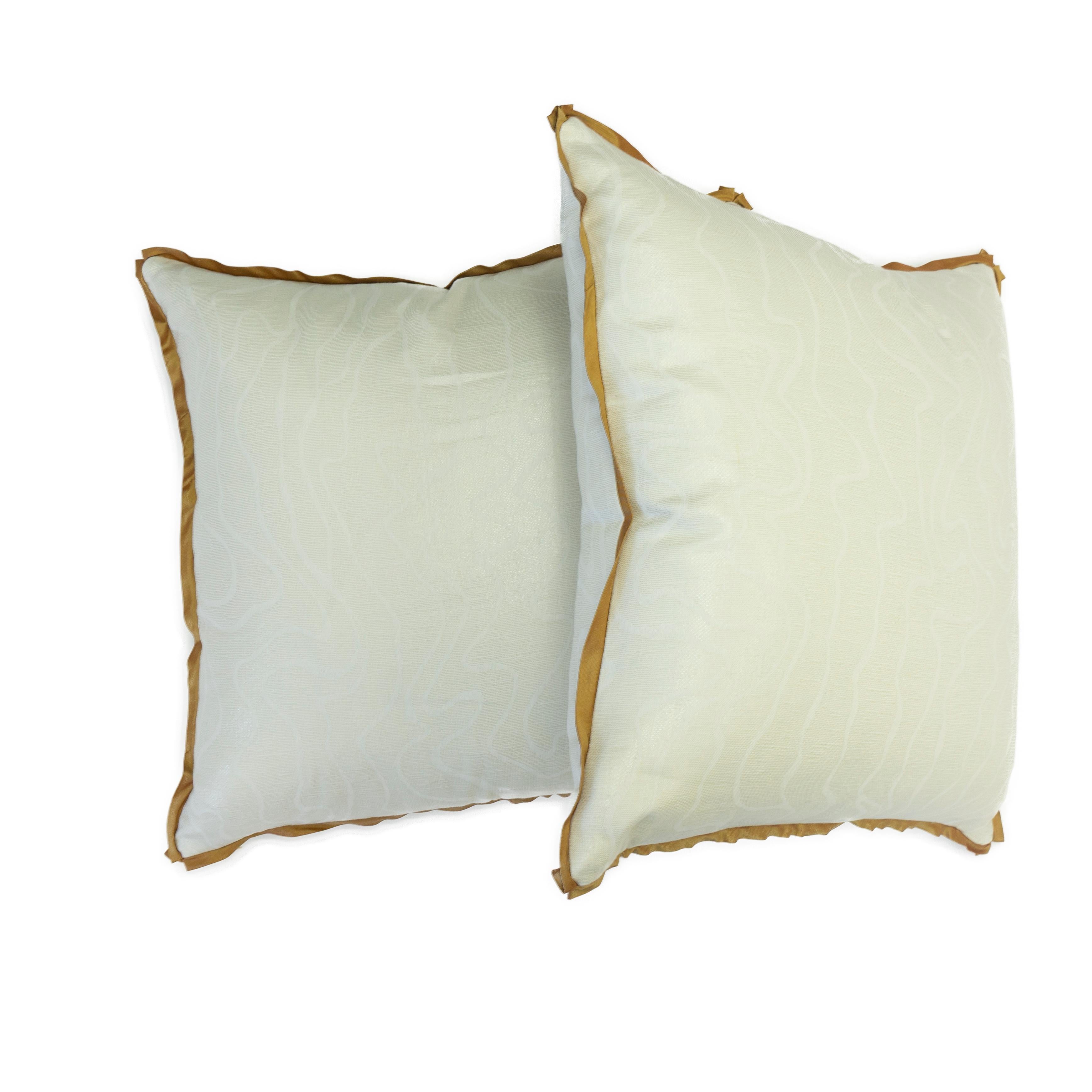 These shimmering pillows were hand sewn in a sheer linen fabric with lurex featuring an asymmetrical design with contour lines. The silk trim features neatly folded 
