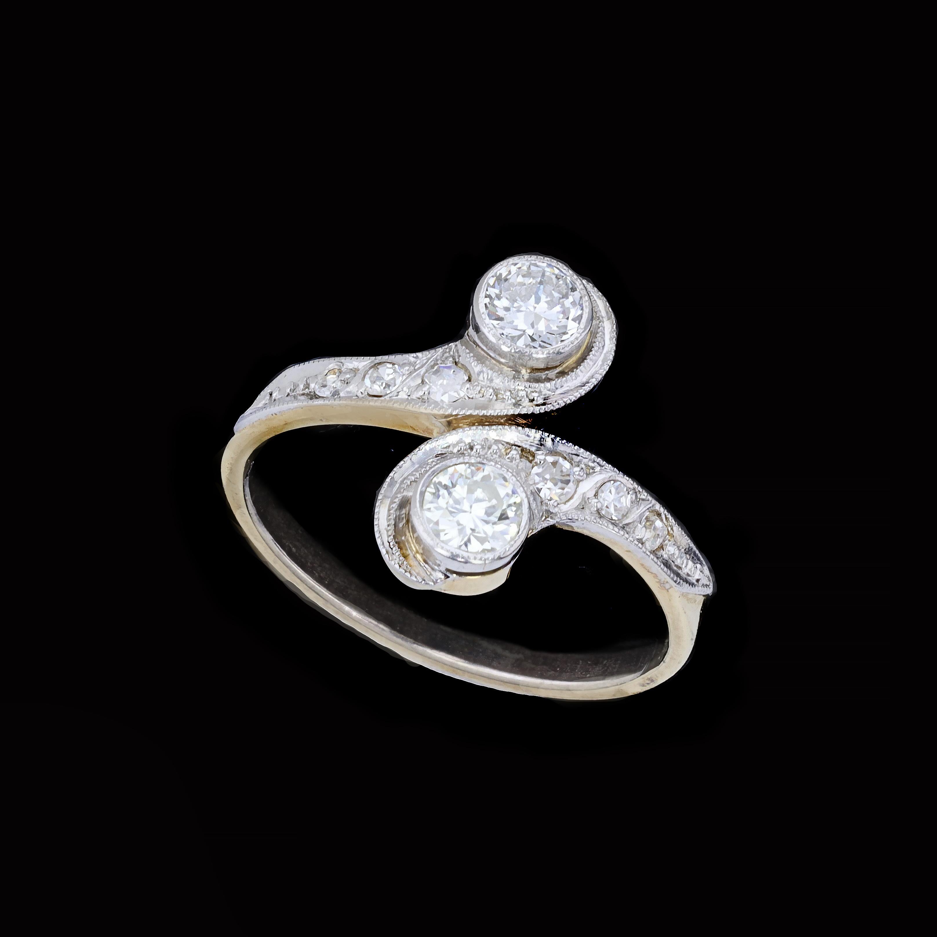 Harmony, beauty, proportion and balance all rolled into a unique package. This Victorian 14K yellow and white gold estate ring is set with two old mine cut diamonds that weigh approximately 0.70ct. The color of the diamonds is I with VS clarity. The