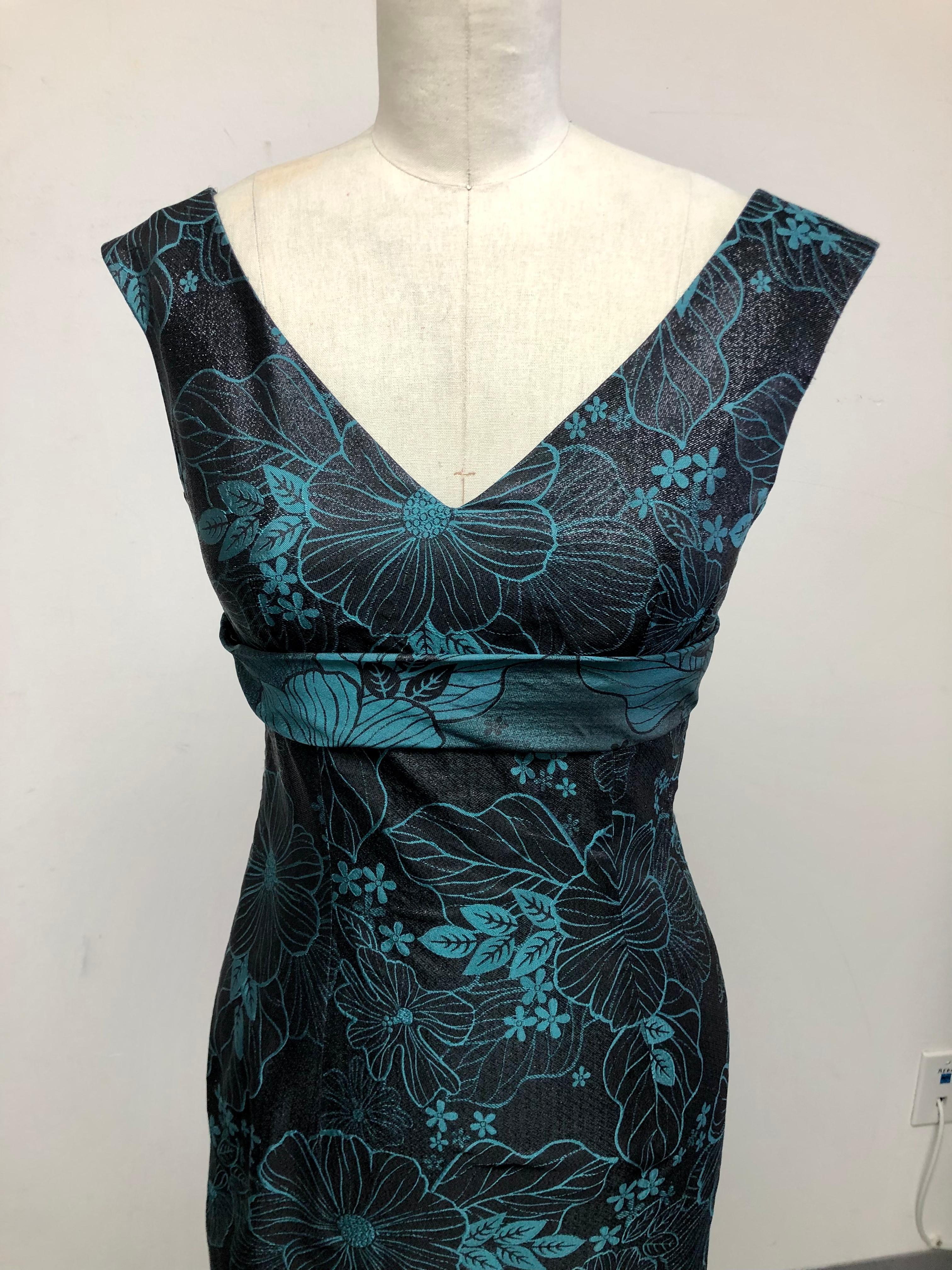Deep double V Neck Slim Dress in Black Jet Brocade with Turquoise Floral Motif. Perfect for cocktails and even black tie. Wedding guest appropriate and truly charming low V back secured with a flat back bow for making a chic exit!  Season- less and