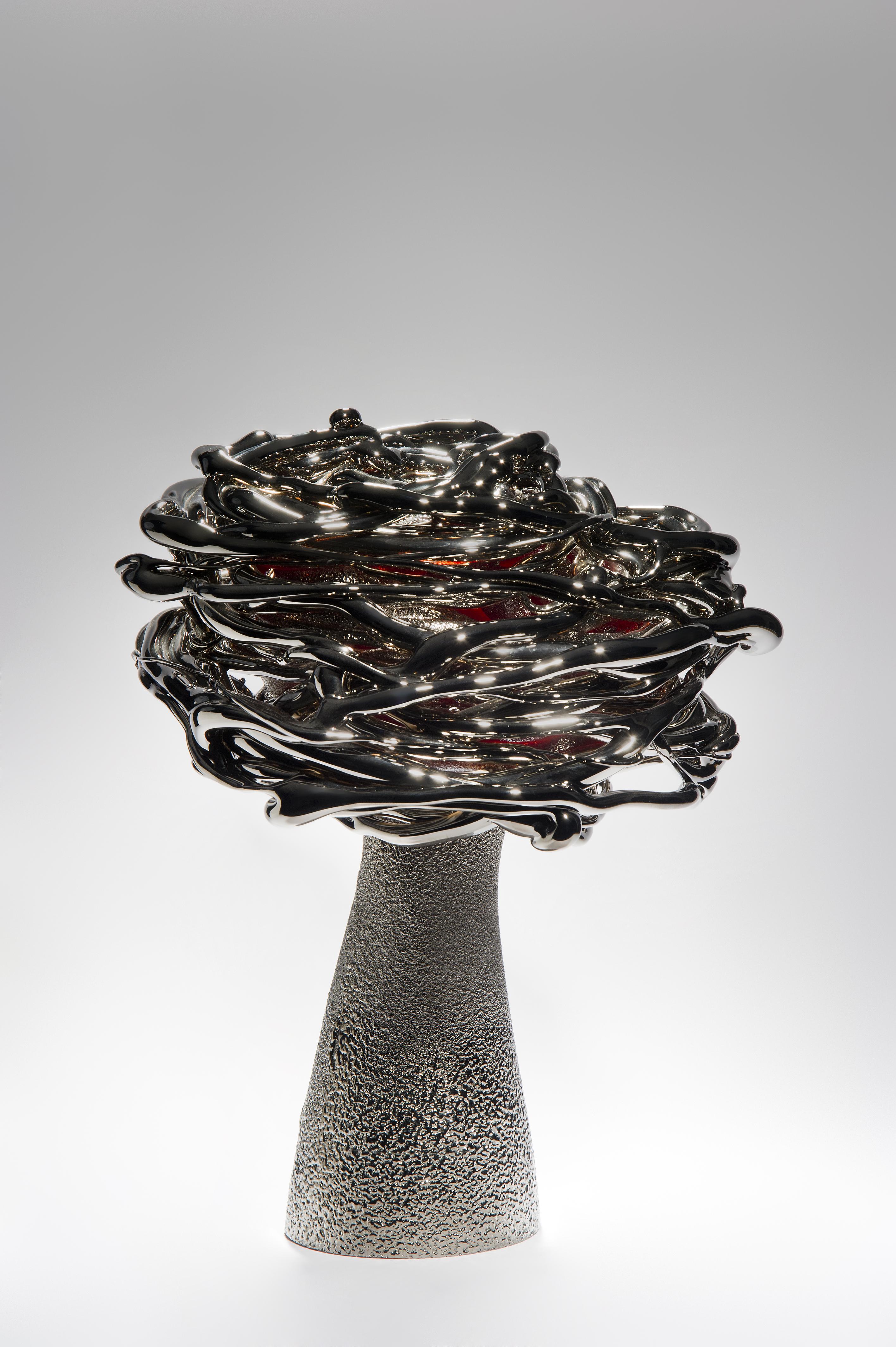 Shining at night, is a unique platinum and glass stylised tree sculpture by the Lithuanian artist Remigijus Kriukas. Glass is blown and hot sculpted to create this substantial artwork, the final piece is finished with a fine coating of