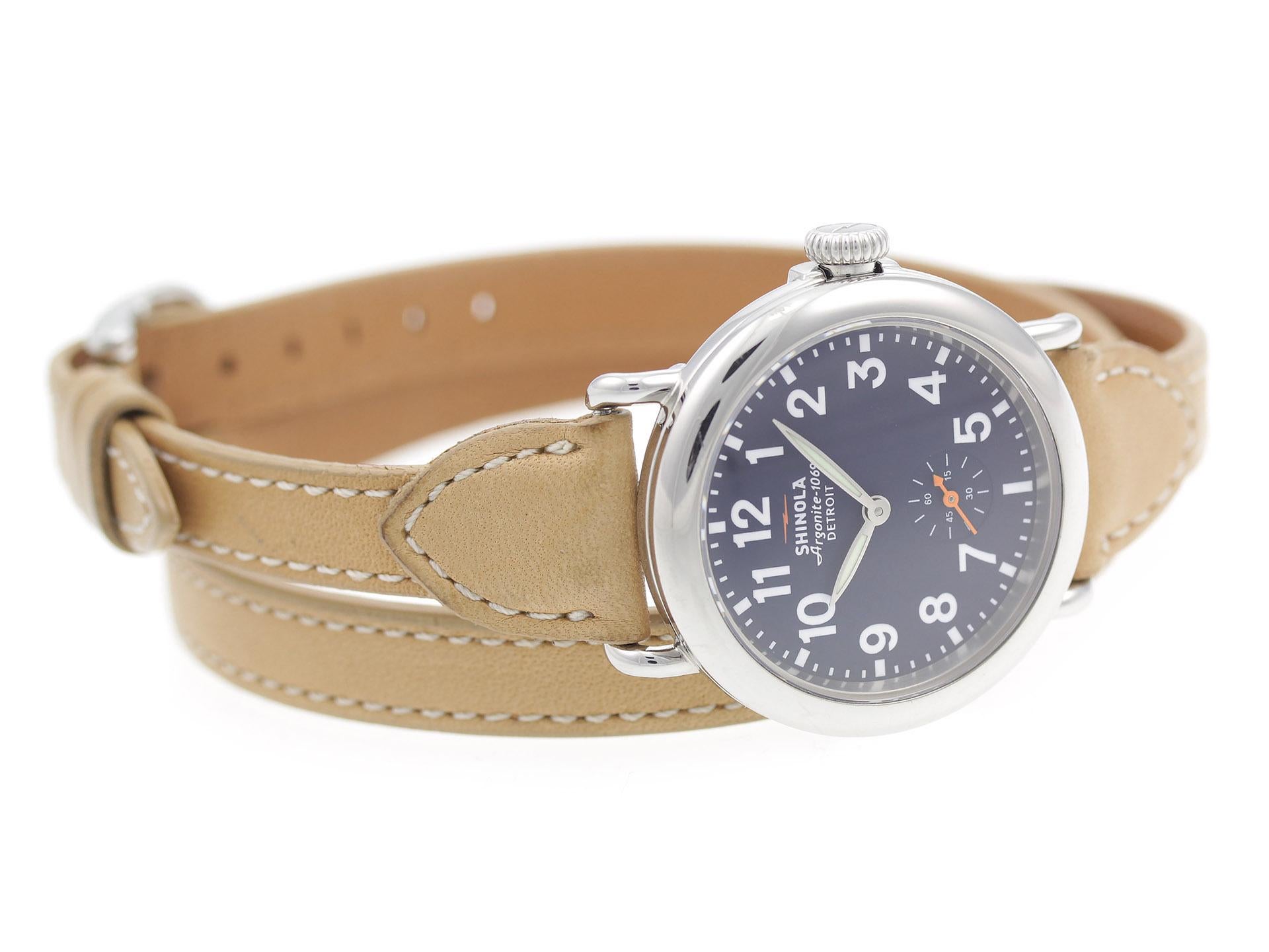Stainless steel case, on brown triple wrap leather strap Shinola The Runwell 36mm 10000260 ladies’ watch with midnight blue dial.

Watch	
Brand:	Shinola
Series:	The Runwell 36mm
Model #:	10000260
Gender:	Ladies’
Condition:	Good Pre-owned, Scratches