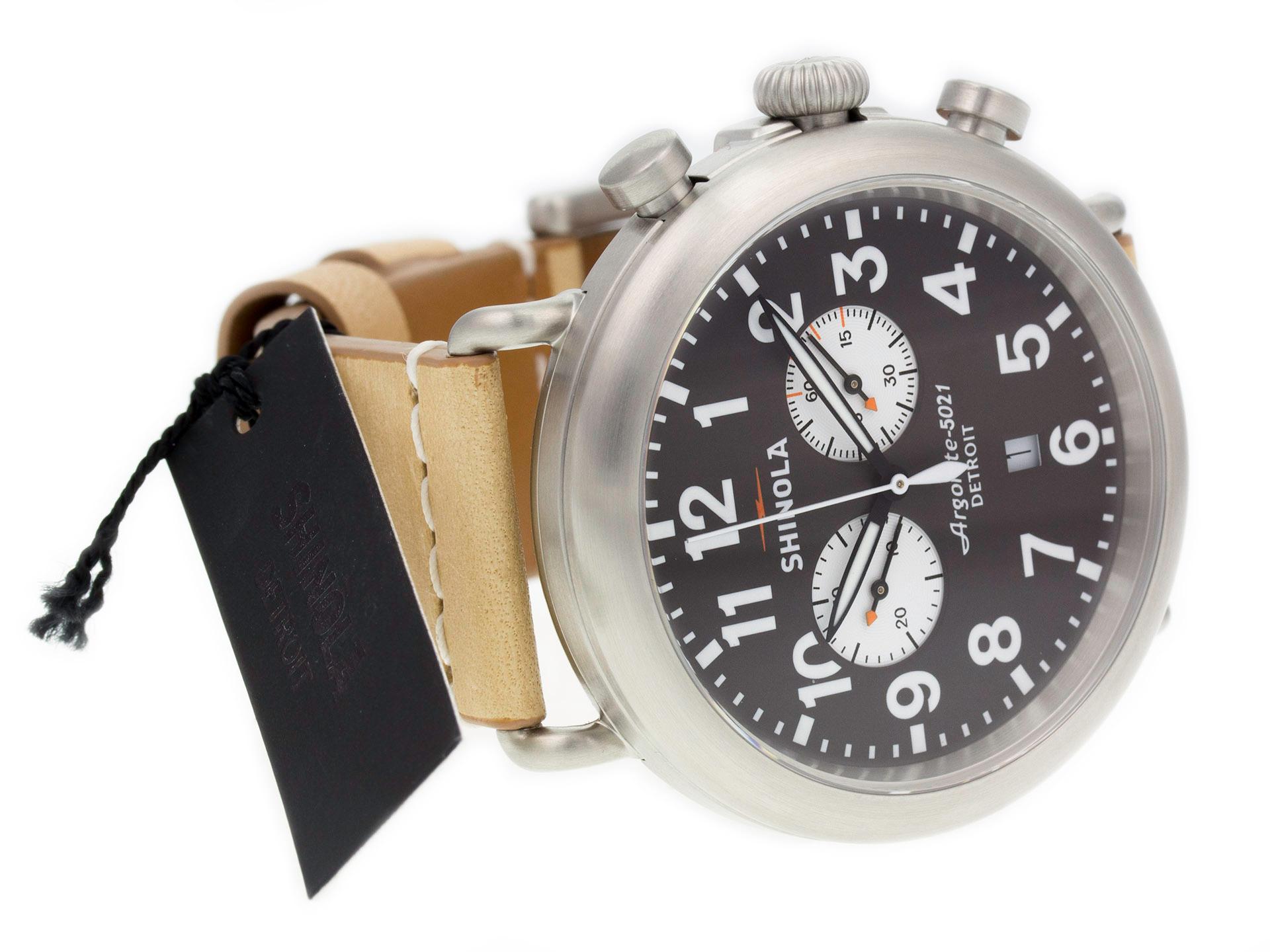 Steel Shinola The Runwell quartz watch with a 47mm case, brown-gray dial, and tan leather strap with tang buckle. Features include hours, minutes, seconds, date, and chronograph. Comes with a Deluxe Gift Box and 2 Year Store