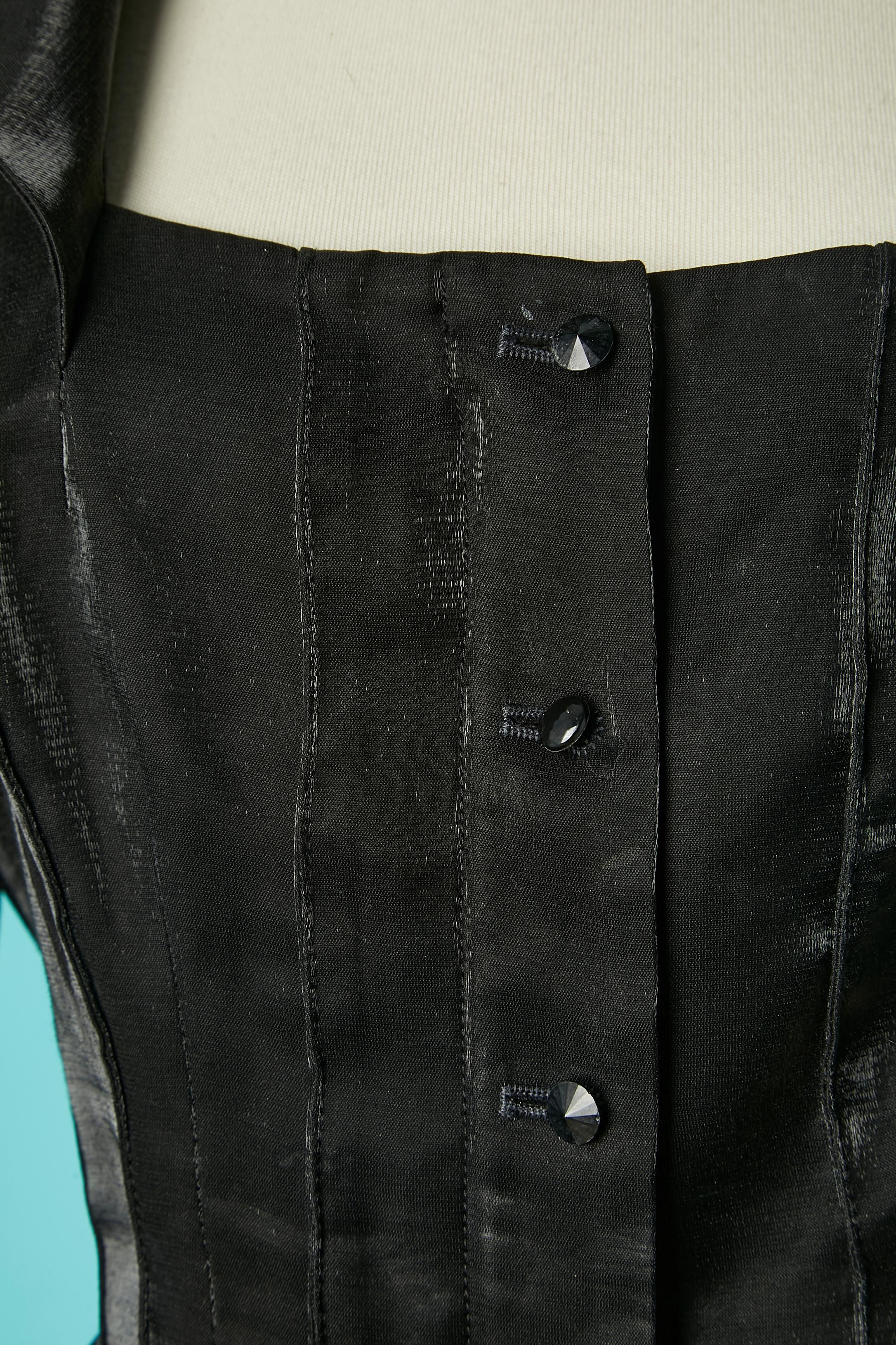 Jupe de soirée noire brillante avec jupe asymétrique. Composition du tissu principal : 91% polyester, 9% rayonne. 
Pad d'épaule. Fermeture à glissière cachée sur le milieu du devant et patte de boutonnage sur le dessus. Volants sur le bord des