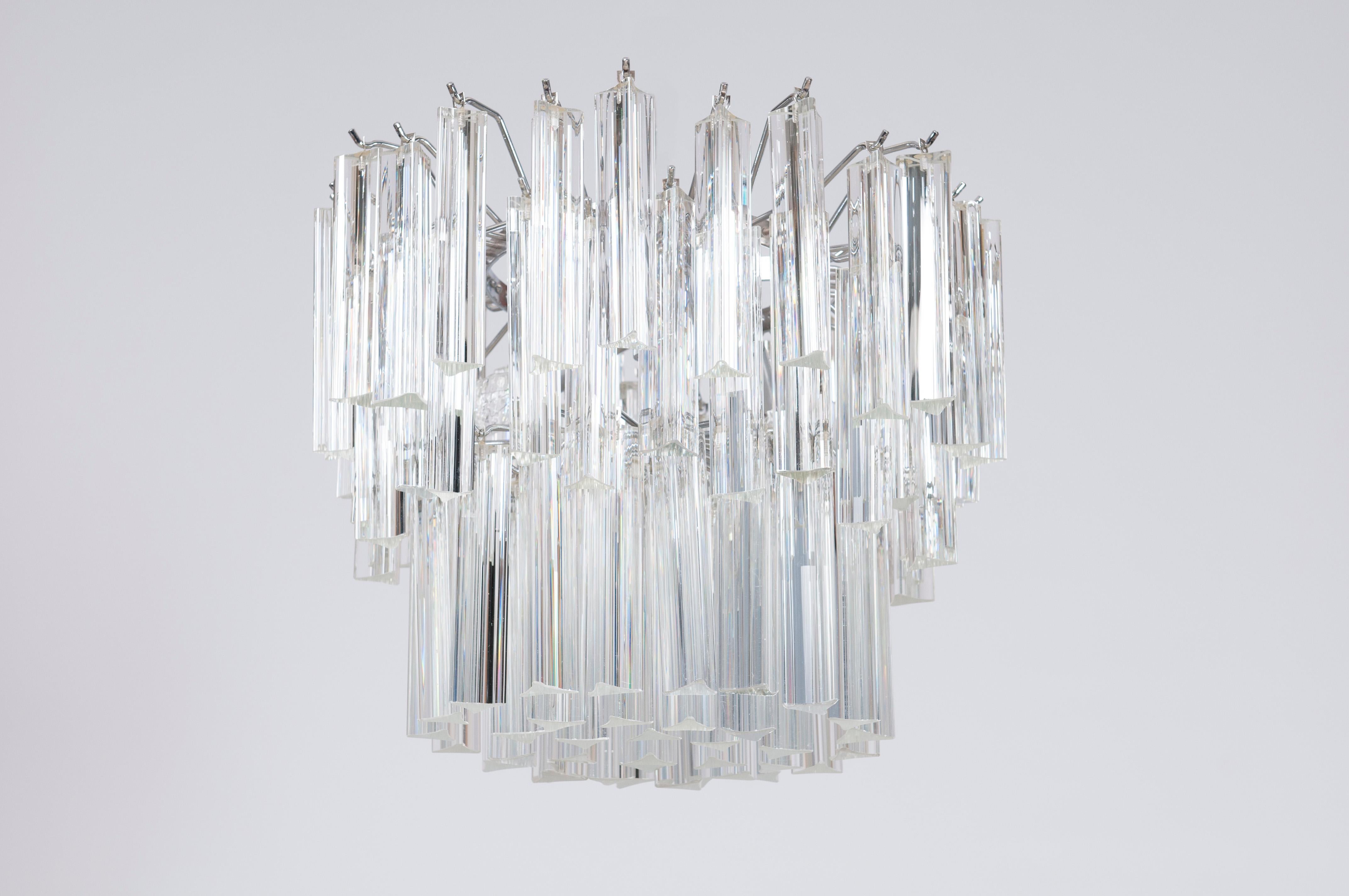 Shiny Camer Murano Glass Chandelier Clear colors Trihedrons 1960s Italy.
Entirely handmade of Murano glass and steel in the 1960s, this luxurious chandelier is a creation of the Venetian glassmaker.
It consists of two rounds of perfectly finished
