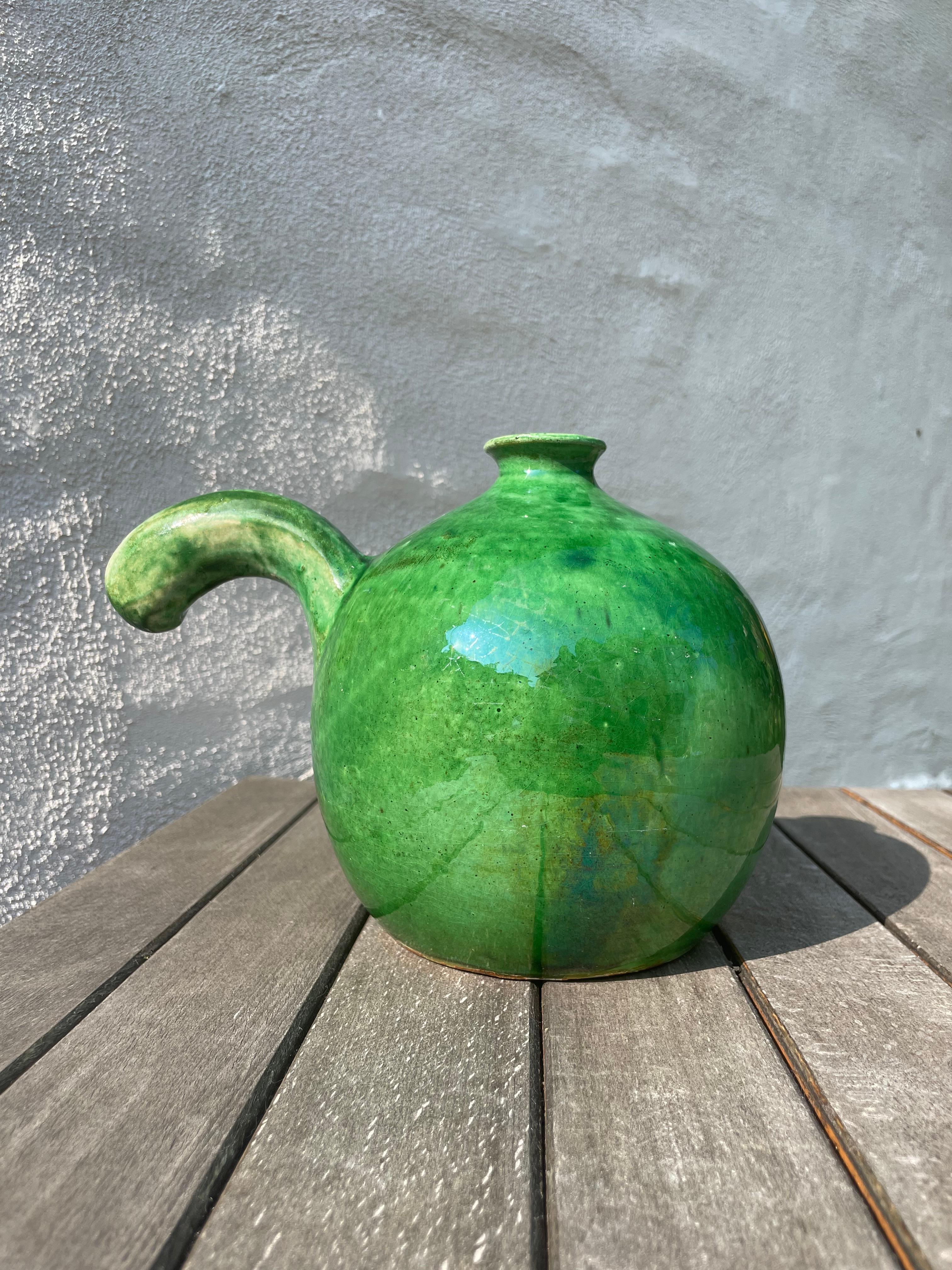 Bright emerald green round and heavy stoneware bottle vase with large curved handle on one side. Stamped under base. Great vintage condition consistent with age and wear.
Denmark, 1950s.