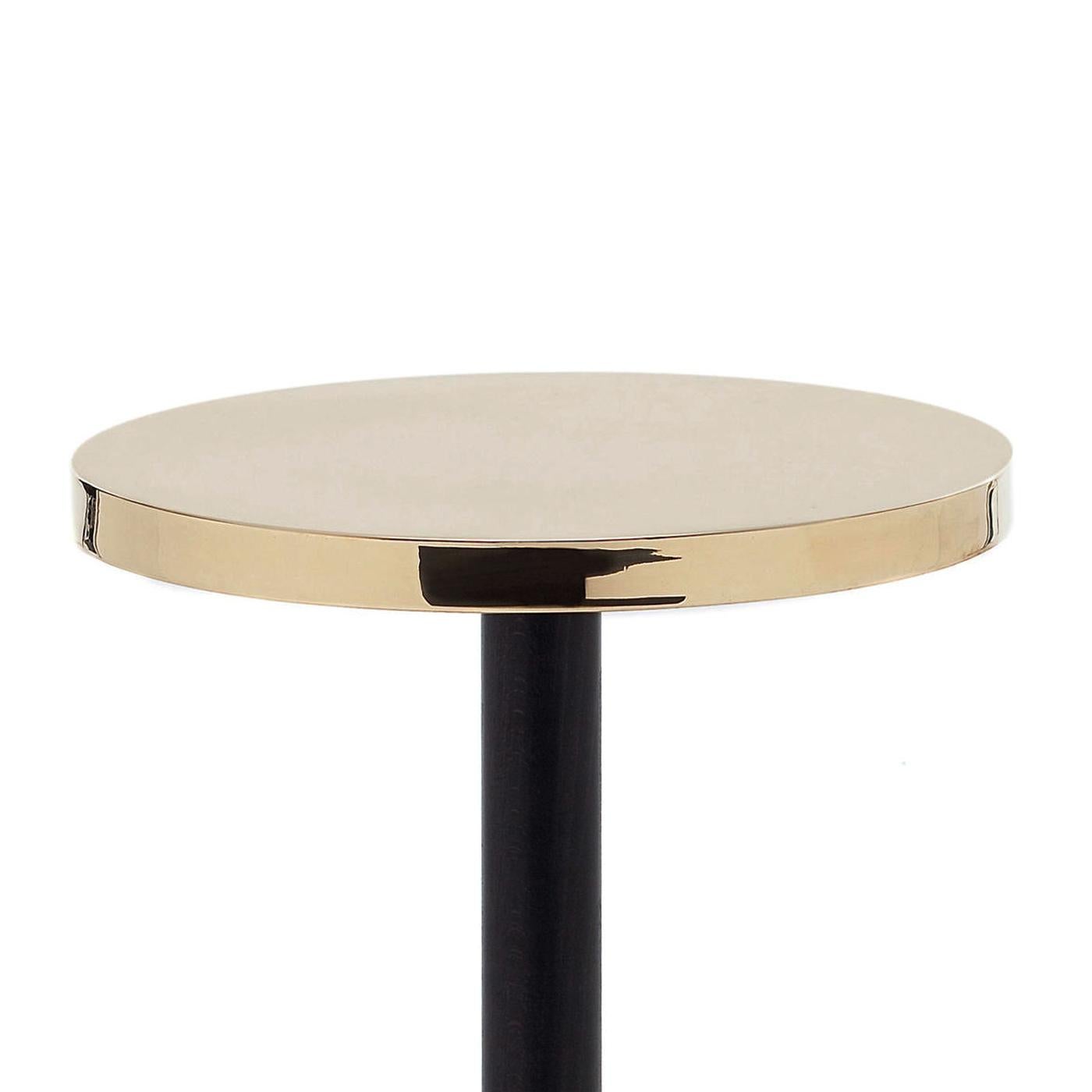 Side table shiny with casted iron base in black finish,
with wooden column base in black finish and with polished
glossy brass top.