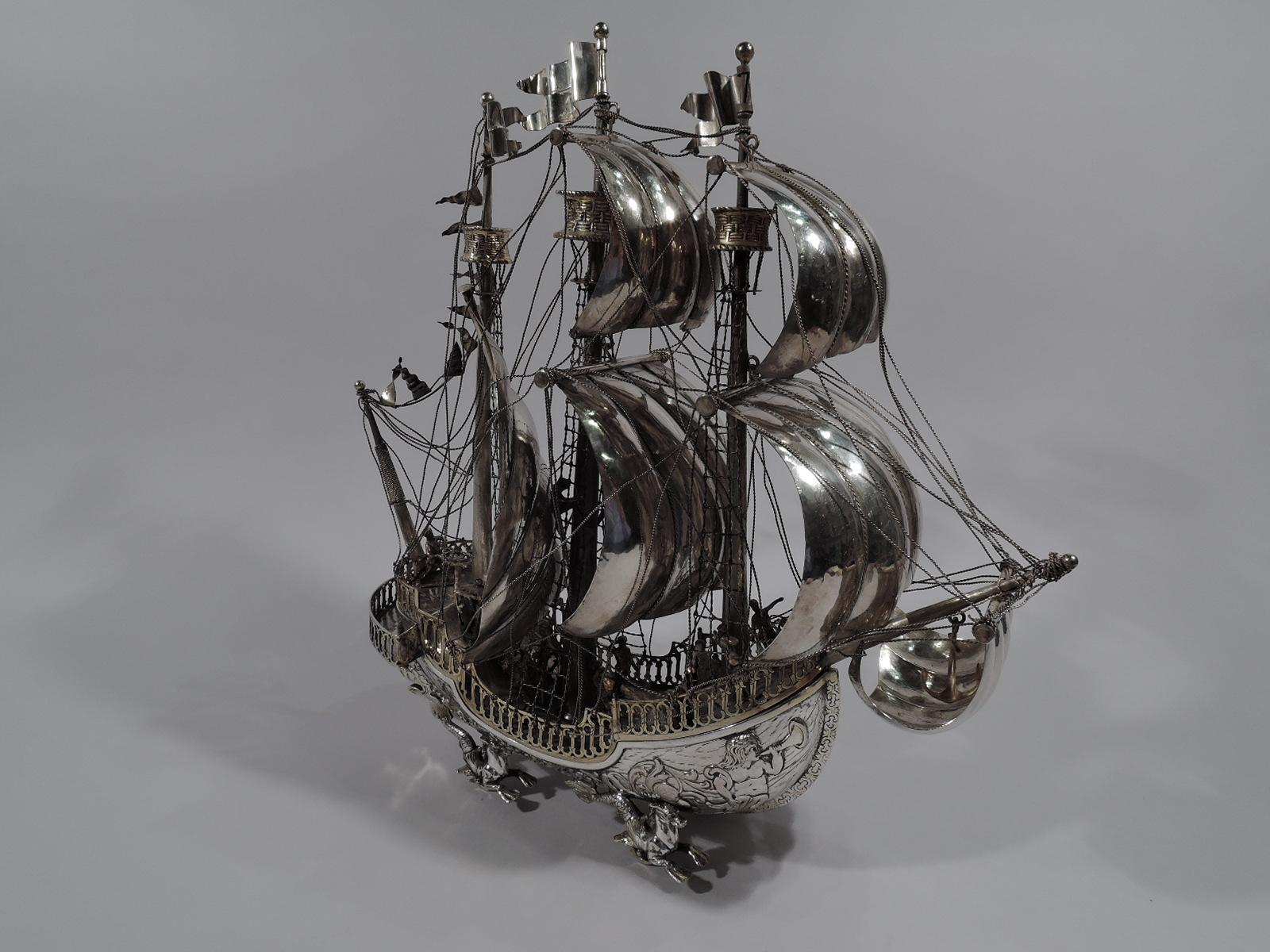 Turn-of-the-century German sterling silver 3-mast galleon nef. Imported to England by Lionel Spiers in London in 1924. Sides have finely delineated “wood” planks decorated with conch-blowing figures and flowery scrolls. Deck also “wood” with mounted