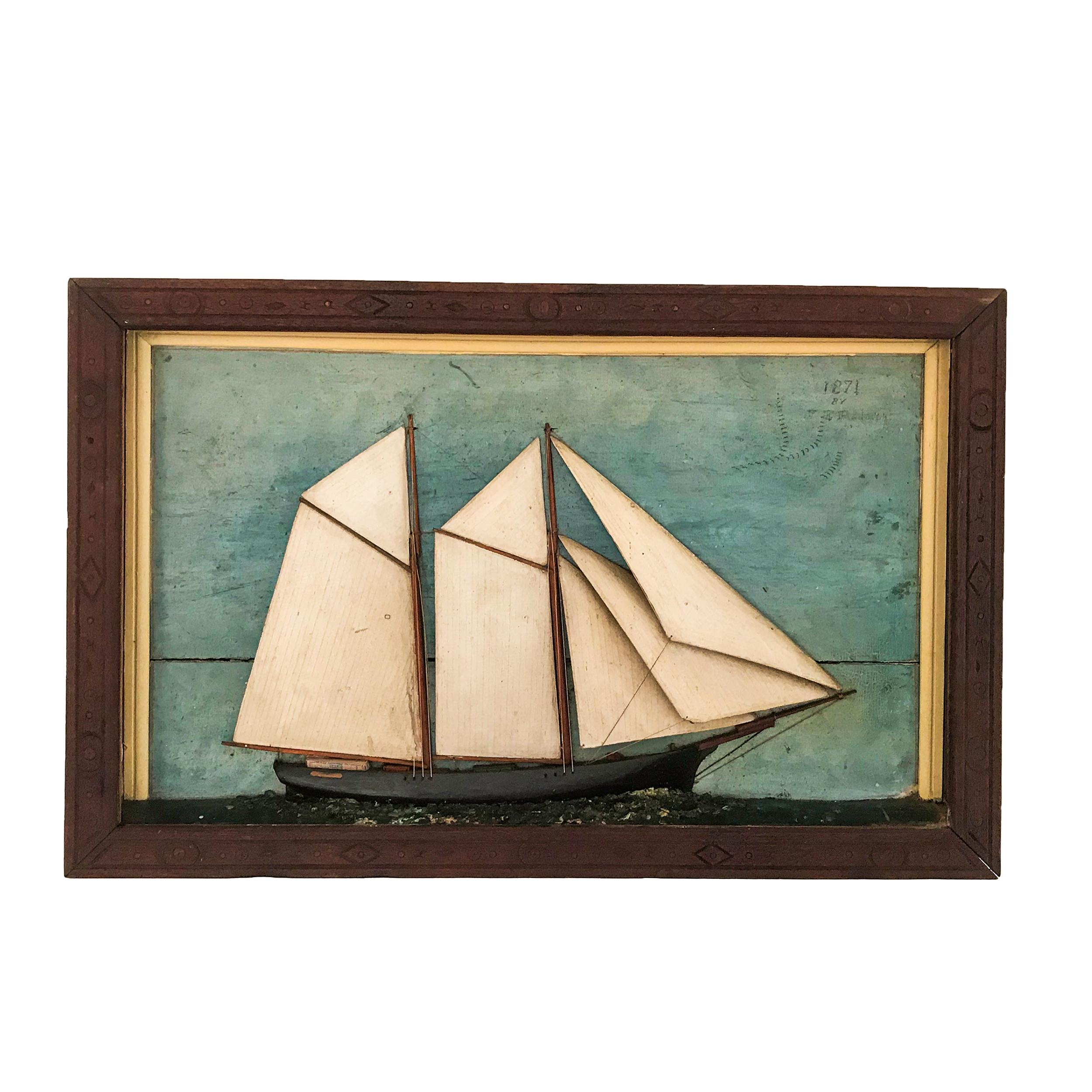 The shadow box depicts a two masted topsail schooner with painted background
Top right of the of the sky is signed and dated “J.E. Rudolph 1871