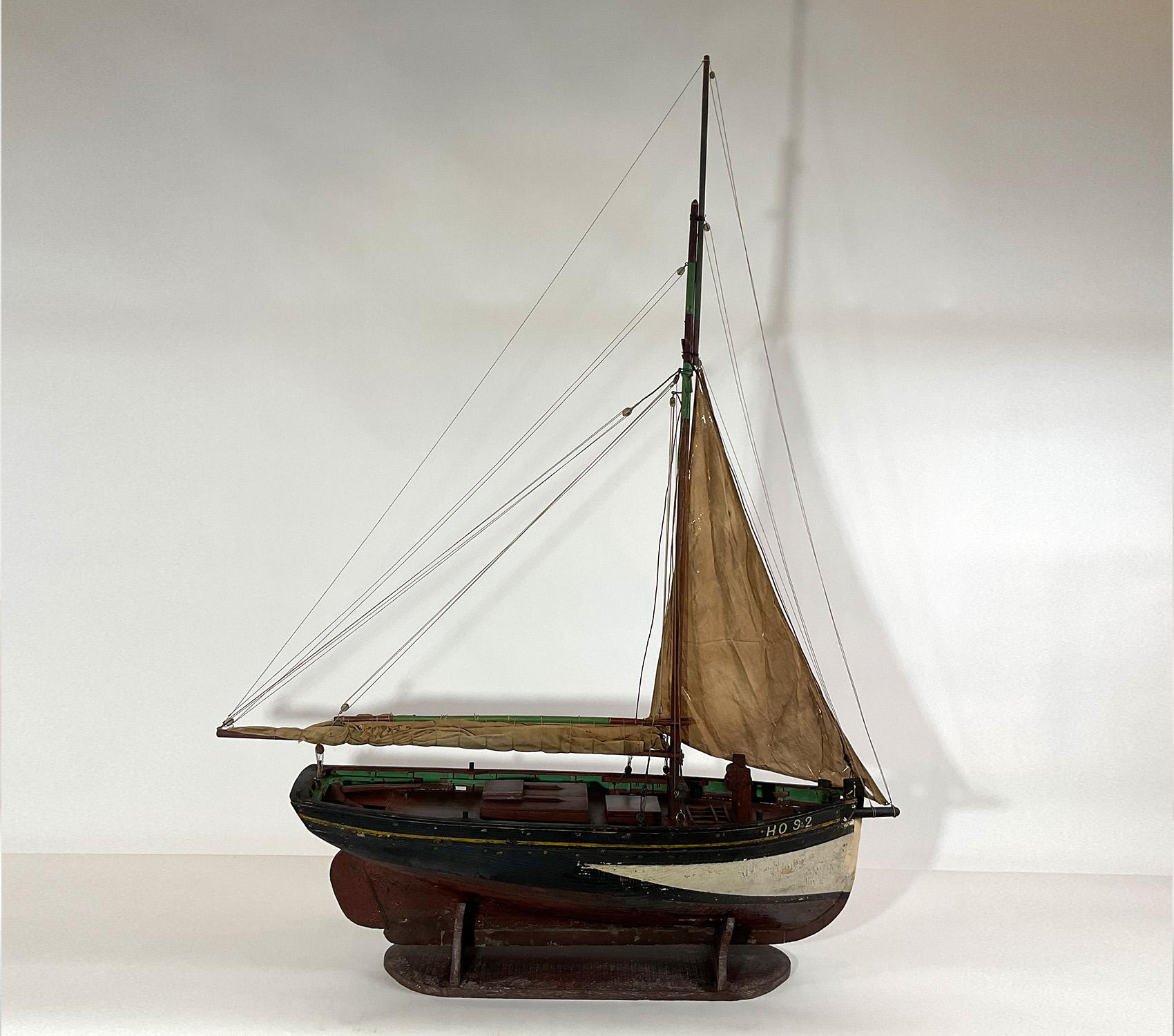 Antique model of the French fishing vessel Delphine Paulette. Hail port is hard to read due to old age splits. The hull is in its old paint. Furled sail. Big boat with a lot of character. A long seine net is on deck. Early twentieth century, the