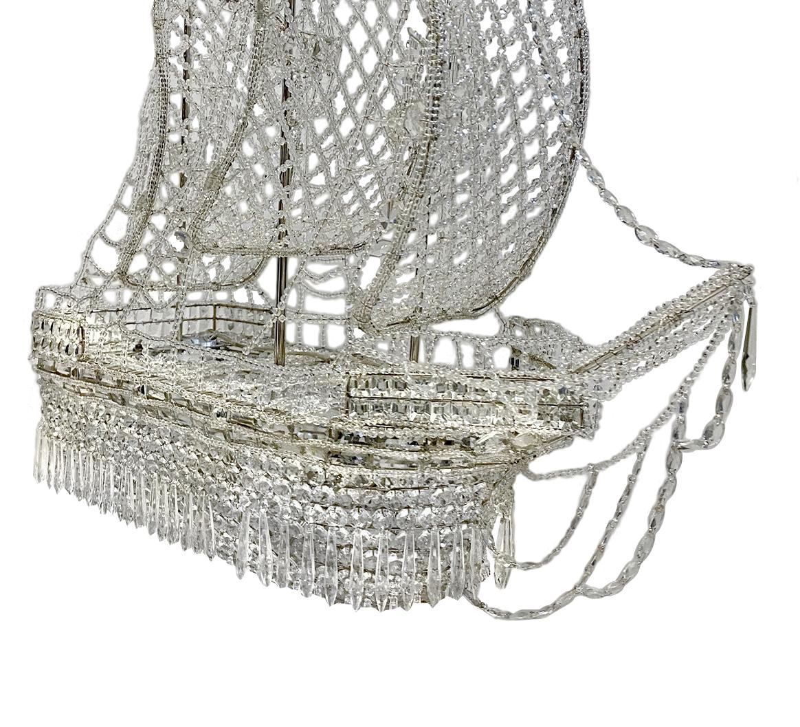 A circa 1930s French crystal chandelier in the shape of a ship with crystal sails, flags, and eight interior lights.

Measurements:
Height 36