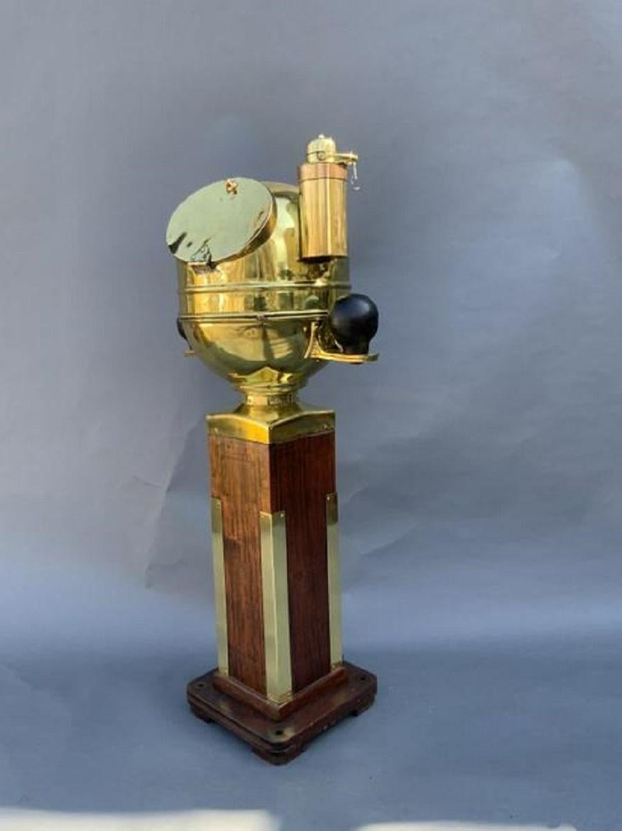 Solid brass highly polished ships binnacle mounted to a wood plinth with brass collar and trim. With hinged front door. iron compensating backs are mounted to brass brackets.

Overall Dimensions: Weight is 83 pounds. 50