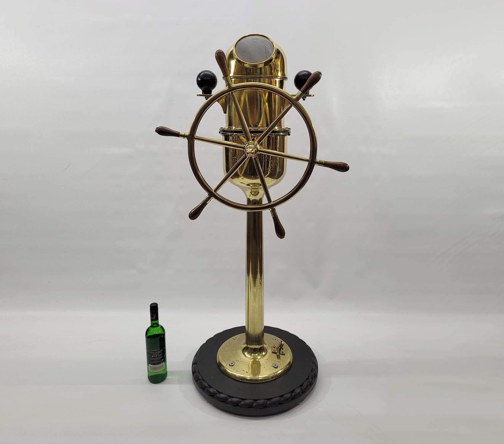 Solid brass yacht binnacle compass with six spoke wheel with varnished wood handles. The nineteenth century gimballed compass bears the mark of Coubro & Scrutton Limited of London. The pedestal is mounted to a thick wood base. The entire unit has
