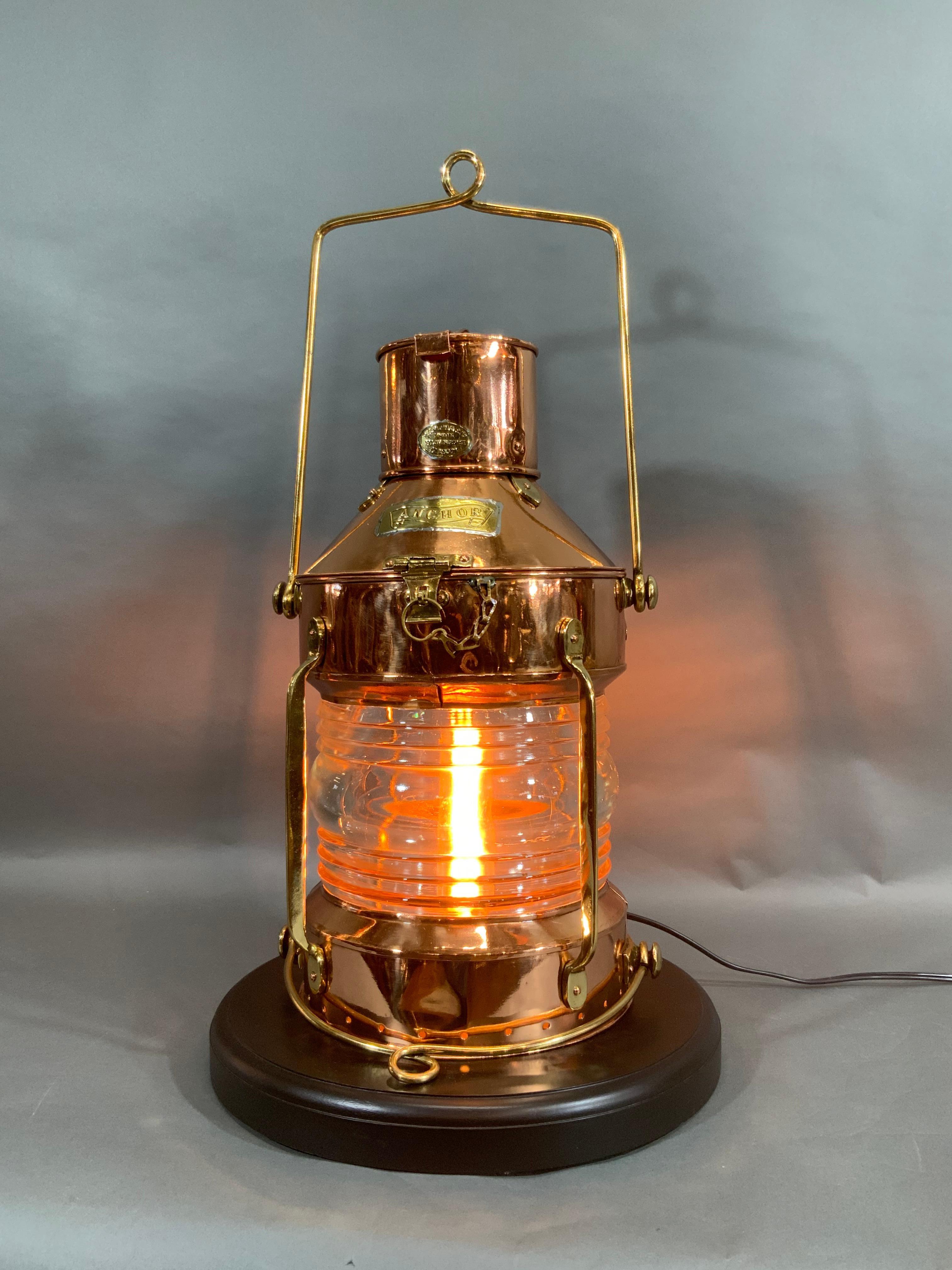 Ship's anchor lantern of polished brass and copper. Maker is R.C. Murray Limited, 37 Cavendish St, Glasgow. Meticulously polished and lacquered, this has been completely restored by us. Glass Fresnel lens, wired with socket for home use. With brass