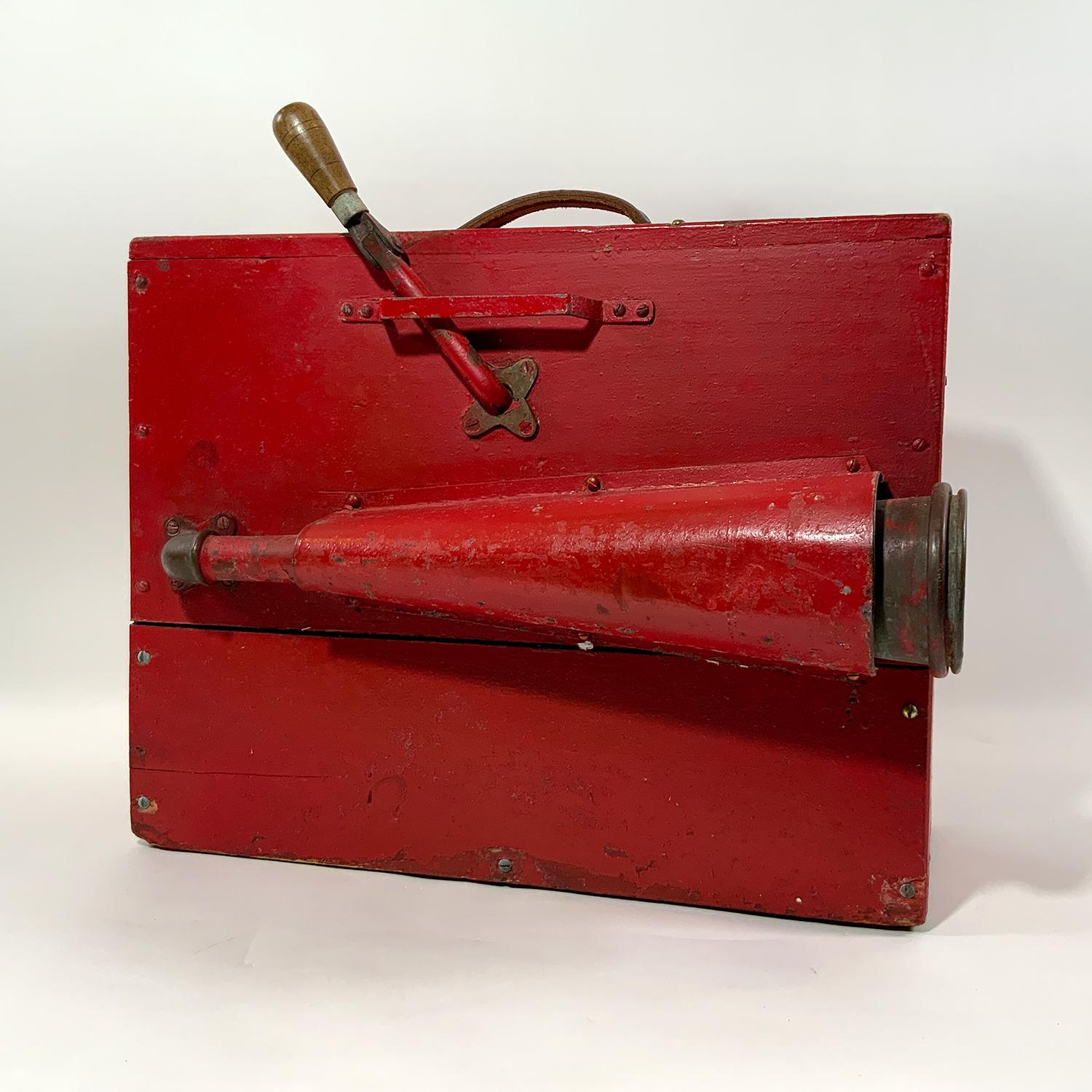 Unique crank operated foghorn with red painted timber box and pipe mounted trumpet, protected by a substantial metal shroud. Sturdy center carry handle. Very loud. Fabulous relic. The external horn with shroud makes this nautical antique quite a