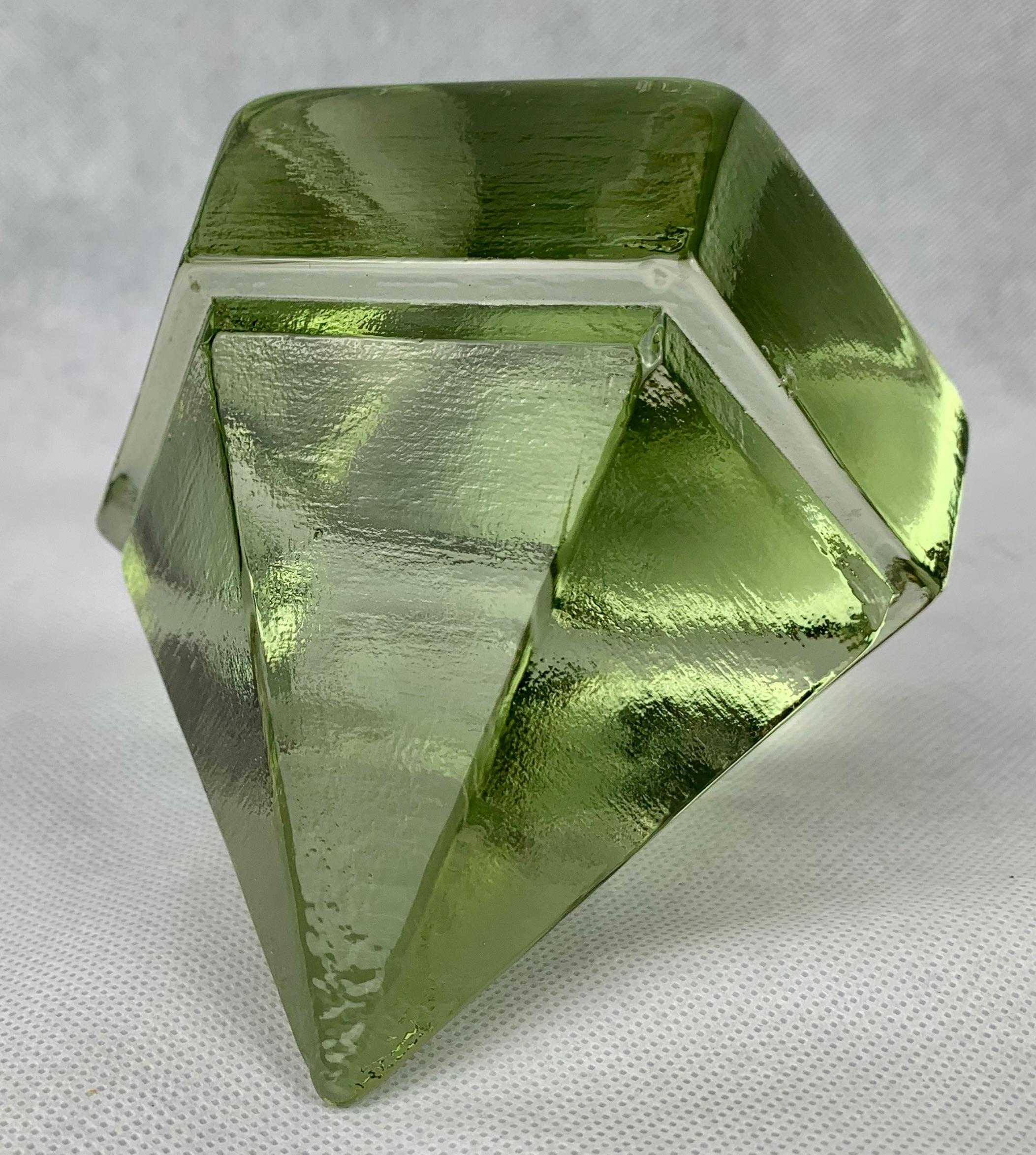 Ship's glass deck prism in the most interesting luminous green glass color. The idea was to put it point down through the deck flooring allowing filtered light below deck. It also makes a great paperweight. You can also use it outdoors to decorate a