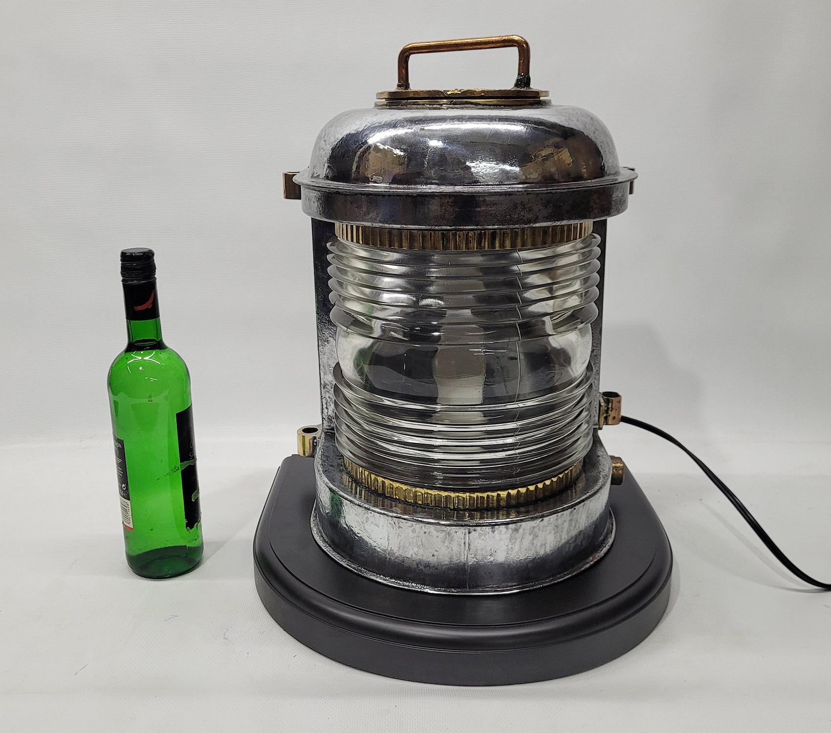 Polished steel ships masthead lantern by Durkee Marine. Glass Fresnel lens with brass trim. Brass cap with carry handle. Mounted to a wood base. Rewired with electric socket. Note: There is a dent on rear corner at bottom. Look at photos.

Weight: