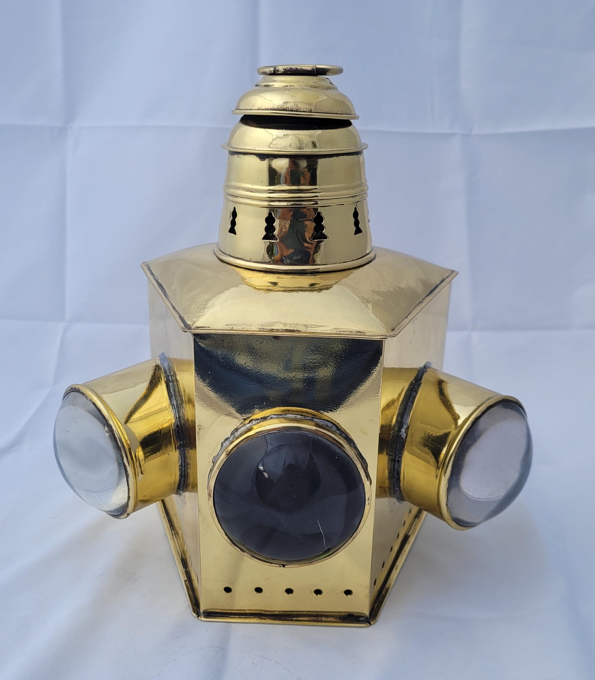 Exceptional Yacht lantern with large red, blue, and clear bullseye lenses. Highly polished and lacquered case. Vented top and carry rings. Hinged door to rear. Oil burner in place. This is the largest of the design that we have ever seen. Quite