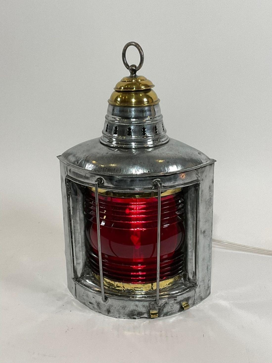 Nautical port lantern. Antique lantern with Fresnel glass lens. Rich ruby red lens. Wired with electricity. Polished steel case and brass cap with carry loop. Two bars protect the lens.

Dimension; 18