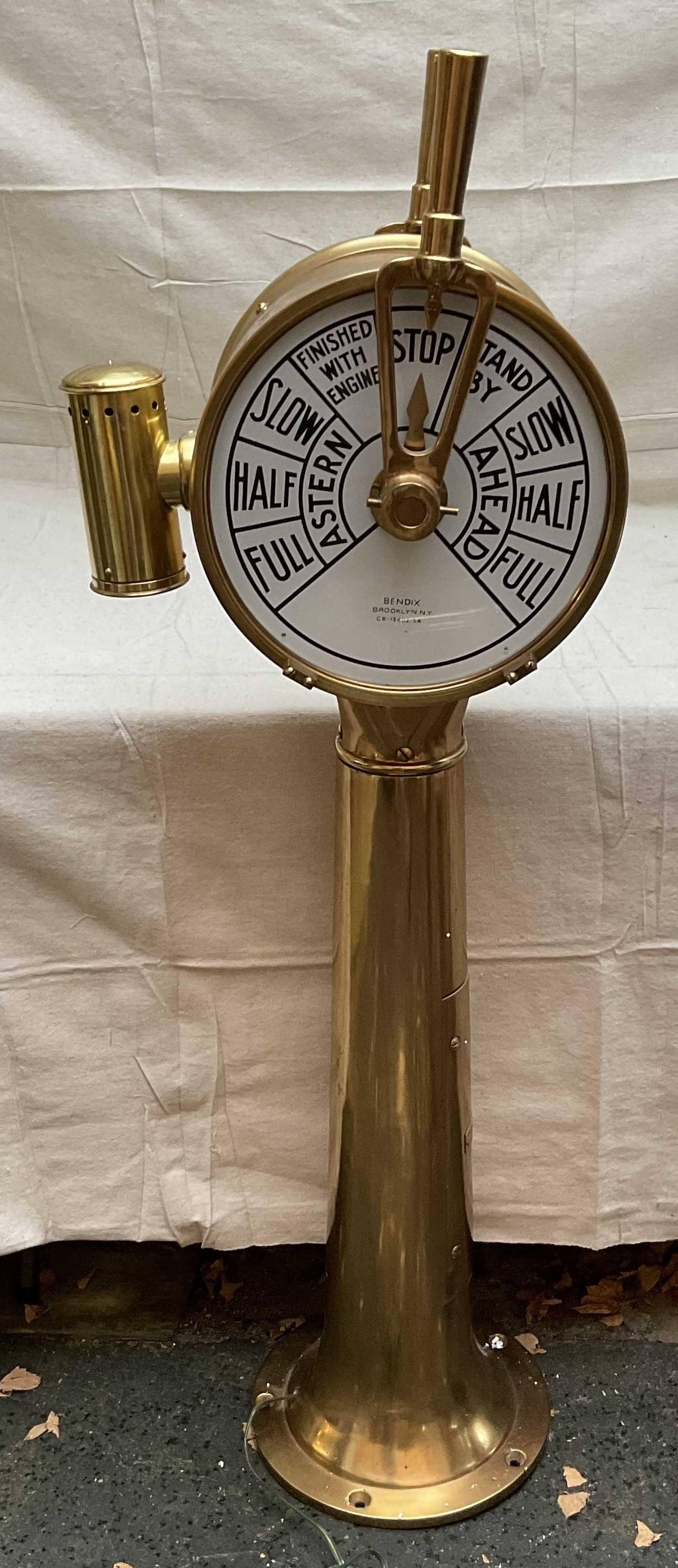 Ships engine order bridge telegraph by Bendix of New York. With internal wiring and lighting emtting a warm glow, polished and lacquered finish. Twin faceplate design. Pedestal has an engraved plate reading Bendix Aviation Corporatio, Marine