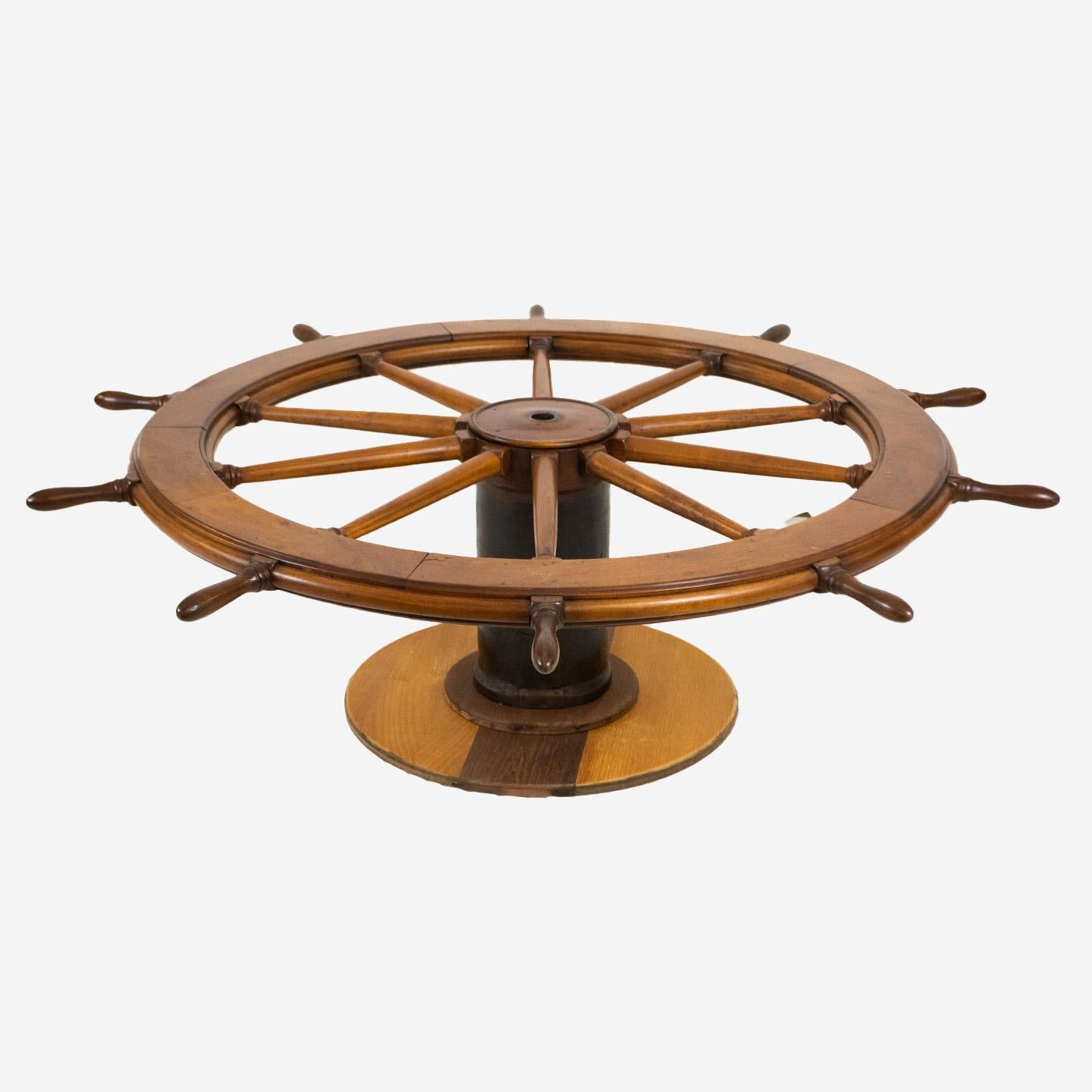 An authentic 65 inch ship's wheel coffee table with ten turned spokes and wooden block base. Nice details, fine joinery and craftsmanship. Crafted in solid mahogany and in very good condition. Circa 1920. Glass top not included.