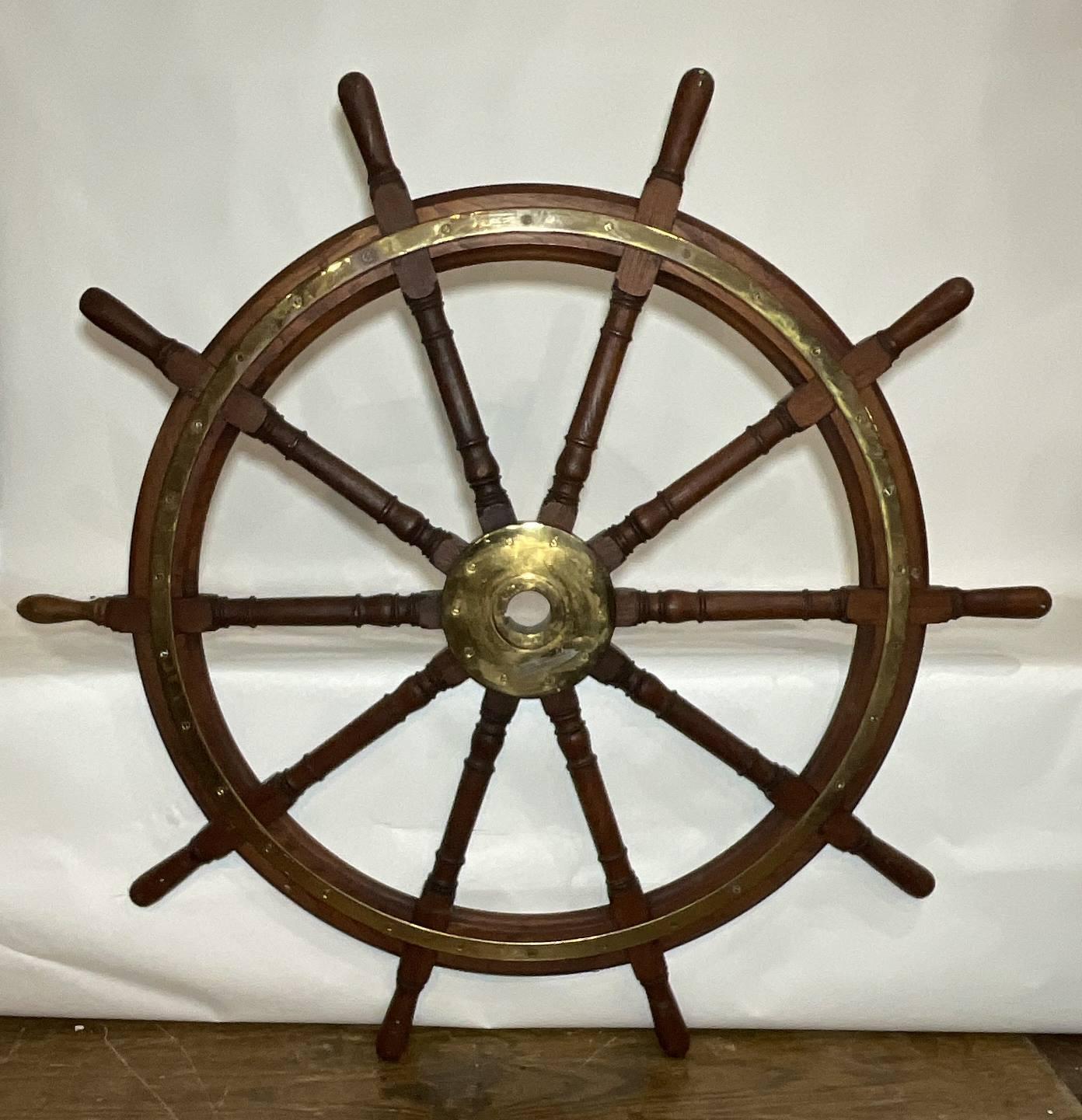 Very large ships wheel with polished brass outer ring and large brass hub. This is a twelve spoke giant of a wheel. Great old oiled finish. Very heavy. Early twentieth century. 70