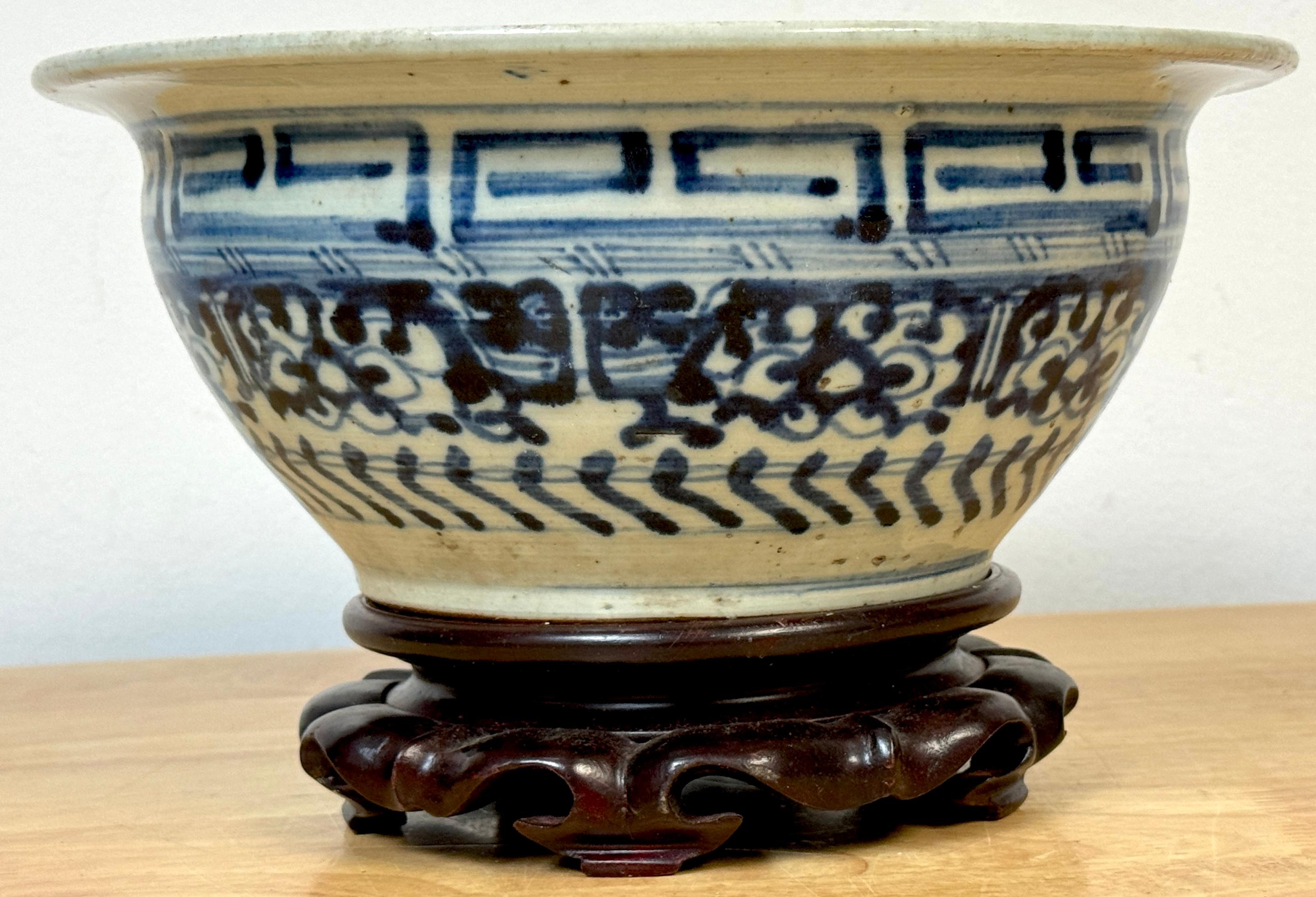 Shipwreck Qing Dynasty, Geometric Pattern Blue & White Bowl & Later Wood Stand, 19th Century or Older

A fine example of better than average Qing Dynasty Geometric Pattern Blue & White Bowl, with wide rim and unglazed interior, measuring 4-inches
