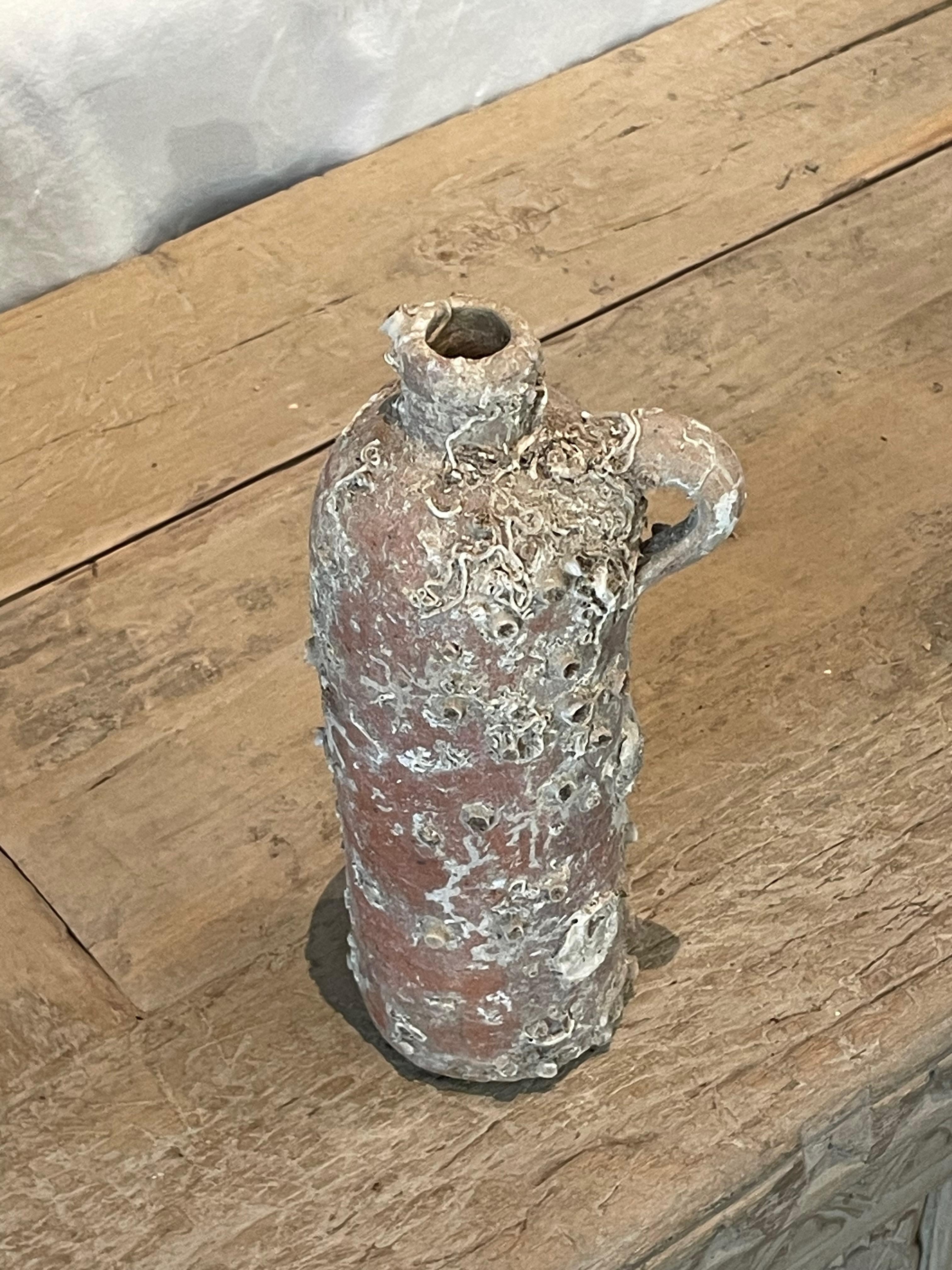 19th century Dutch shipwrecked absinthe bottle.
Single handle.
Original and beautiful barnacles and shells from
being under water for over 100 years.
Three available and sold individually.