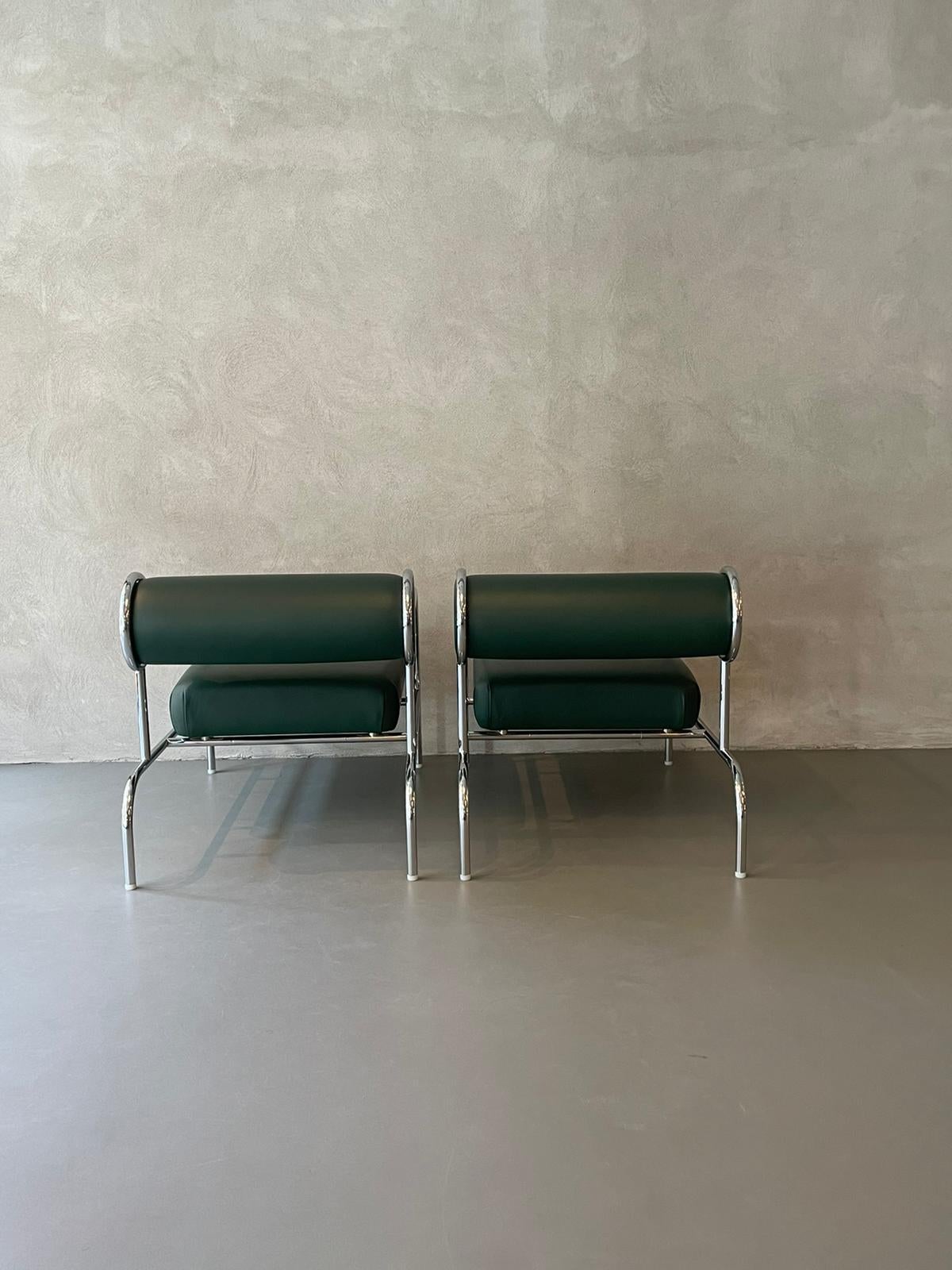 Armchairs designed by Shiro Kuramata in 1970s.
Pair of armchairs with a chromed tubular structure that appears to be light and with a simplified design.
These have a long rectangular padded seat covered in green leather and a cylindrical cushion