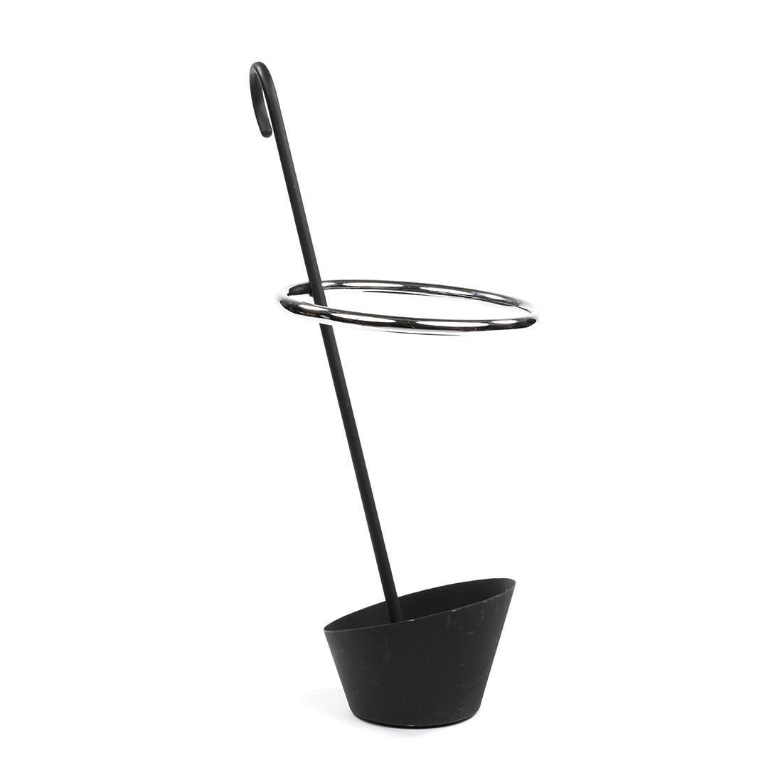 An umbrella stand designed by Shiro Kuramata for Pastoe. A circular polished chrome ring cantilevers cleverly between the black enameled handle and base.
  