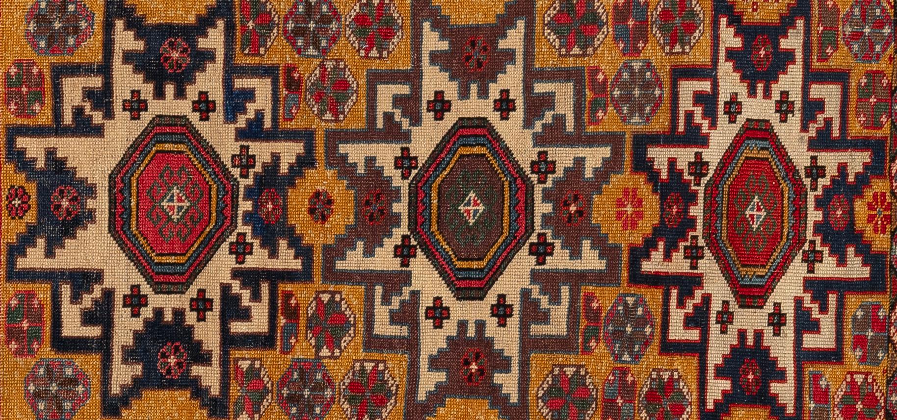 Questo tappeto Shirvan è un'elegante tessitura proveniente dal Caucaso orientale, ammirata per la finezza dell'annodatura e la chiarezza del disegno. Caratterizzato da motivi geometrici nitidi - spesso medaglioni, rombi uncinati o forme floreali
