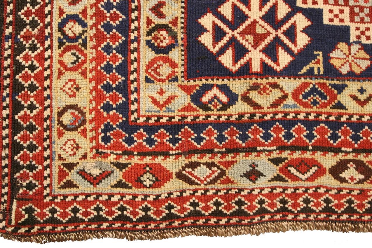 Hand-knotted between 1880 and 1900, this antique Caucasian Shirvan rug measuring 4' 11