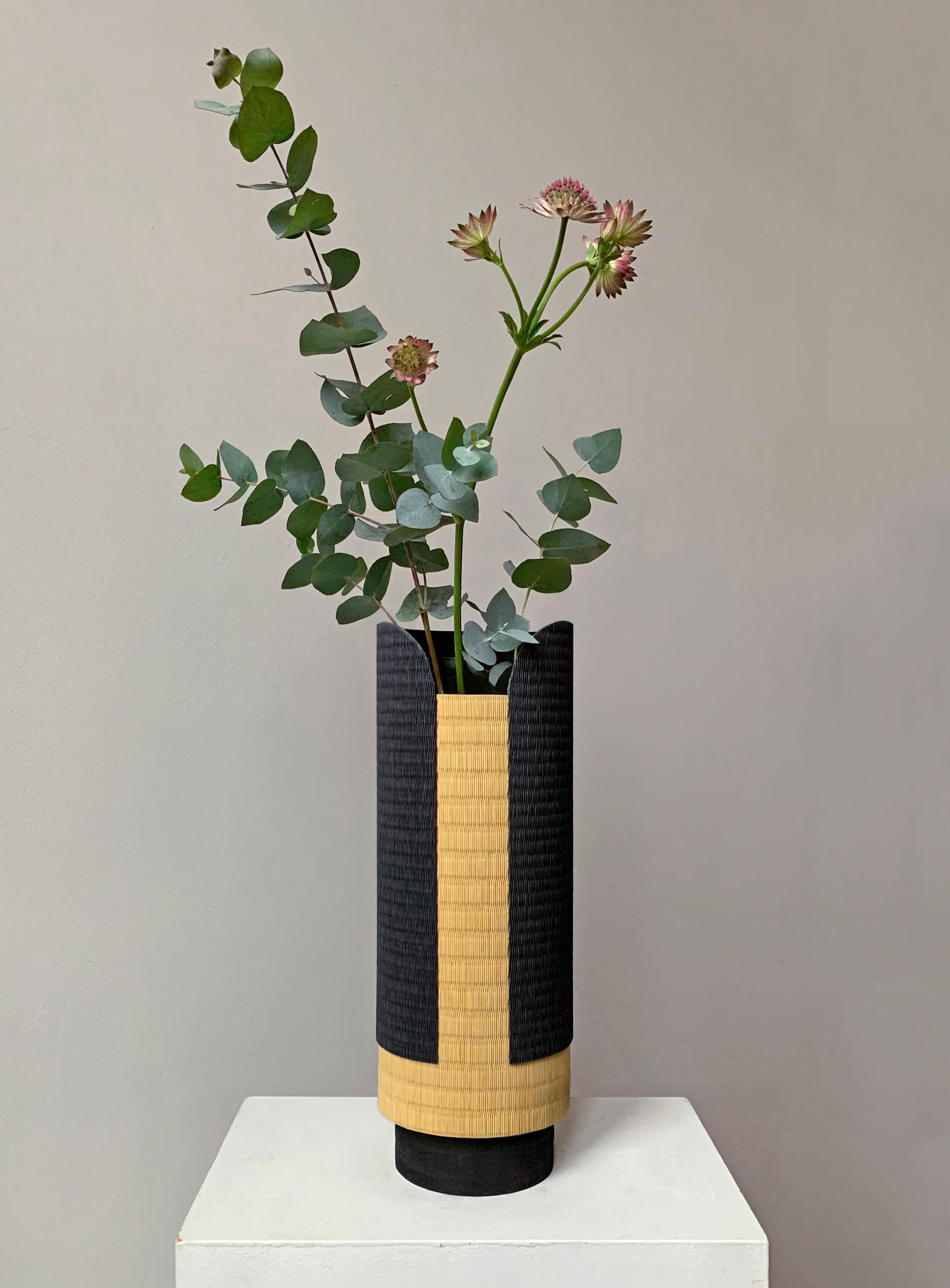 Shizen vase by Astrid Hauton
Dimensions: D 11.5 x H 32 cm
Materials: woven washi paper, waxed black Valchromat.

« Shizen », in Zen tradition, refers to nature as it includes human beings. The Shizen vase has been
designed to embody the natural