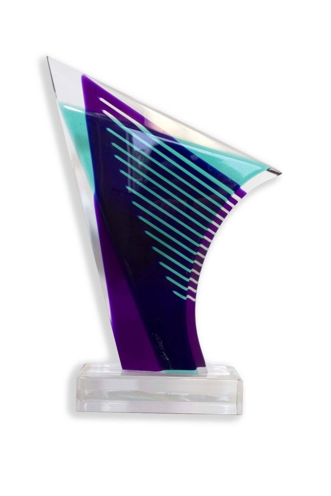 The Shlomi Haziza Lucite Purple and Turquoise Abstract Sculpture is a striking piece of contemporary modern art that captures the essence of fluidity and vibrant colors. Created by the renowned artist Shlomi Haziza, this sculpture showcases a