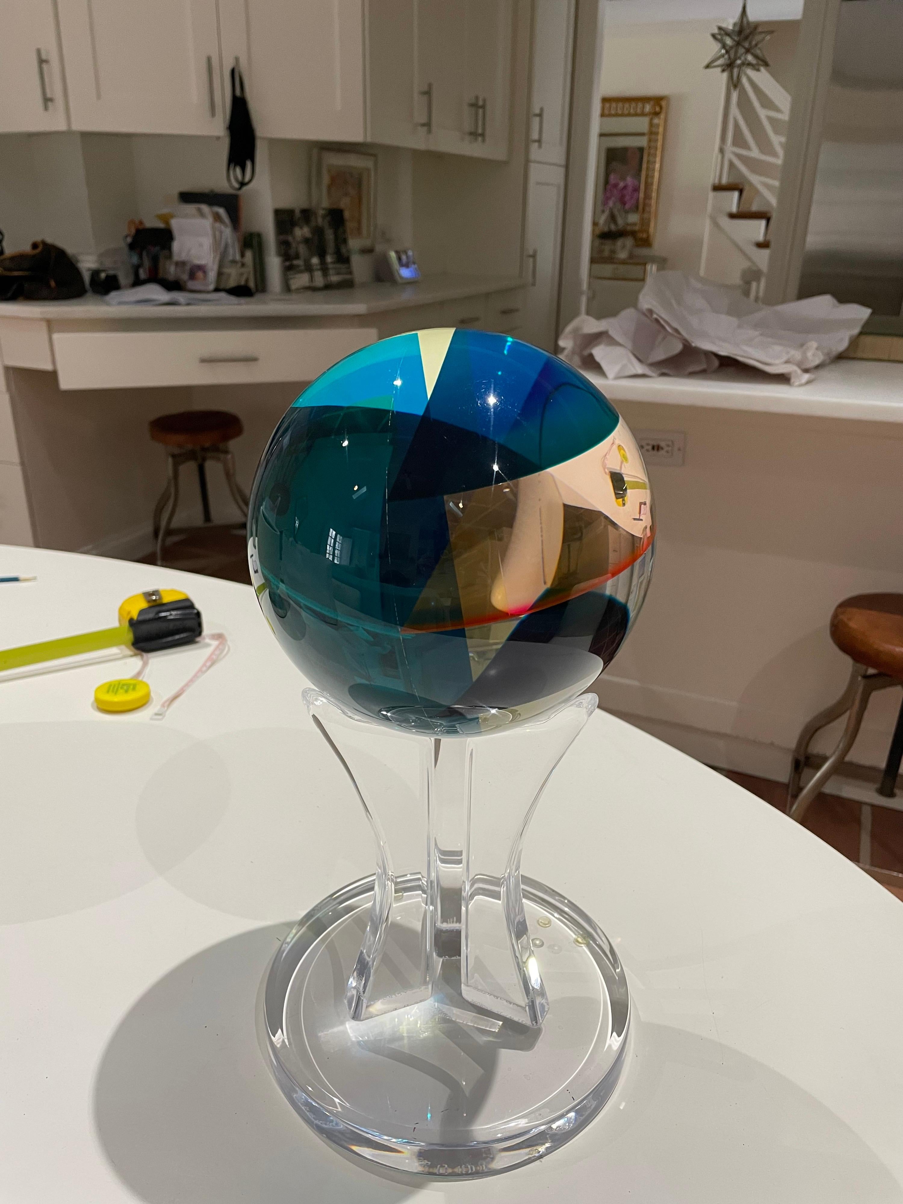 This is a wonderful colorful lucite sphere ,that changes colors depending on light and position of sphere . It is signed on the orb itself . 
This piece was made by Shlomi Haziza no date but probably 80/90s.