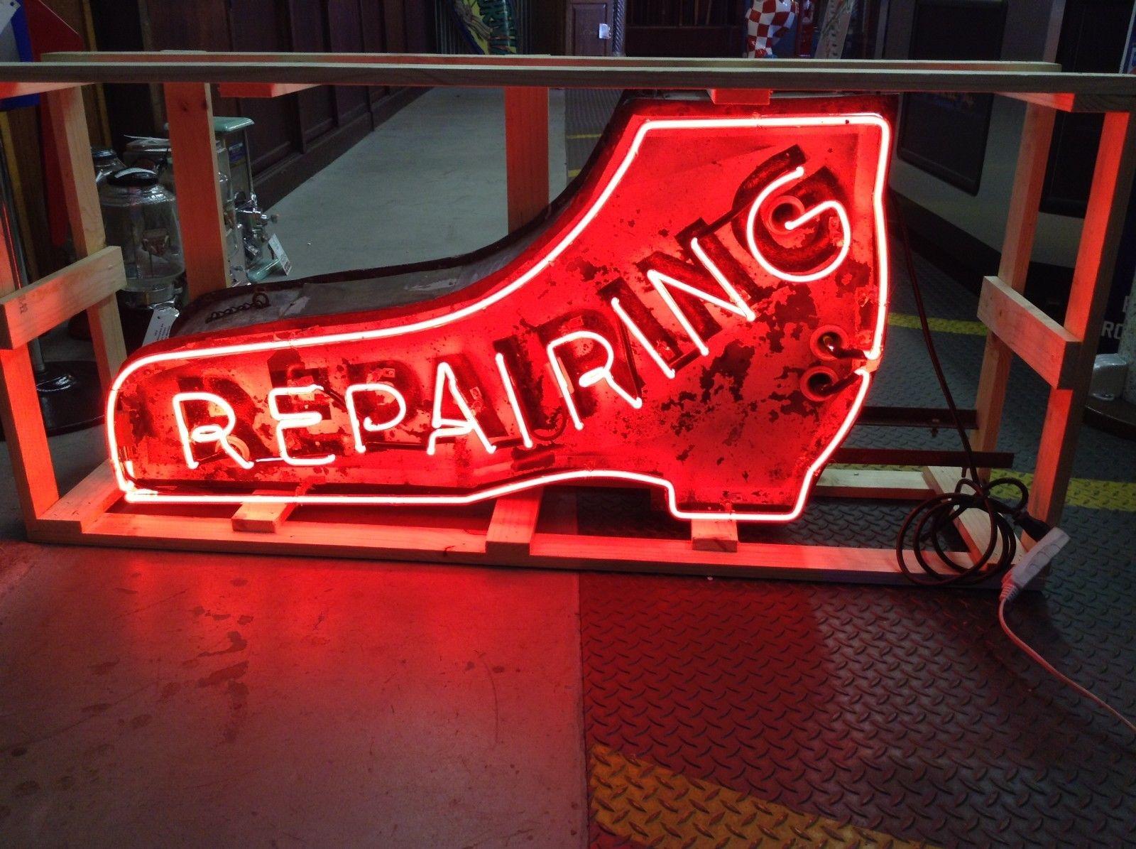 This piece is a vintage outdoor advertising neon sign in the shape of a shoe with the word REPAIRING in red neon.

This would have been used originally outside of a cobblers place of business. The sign looks like it was originally - double sided