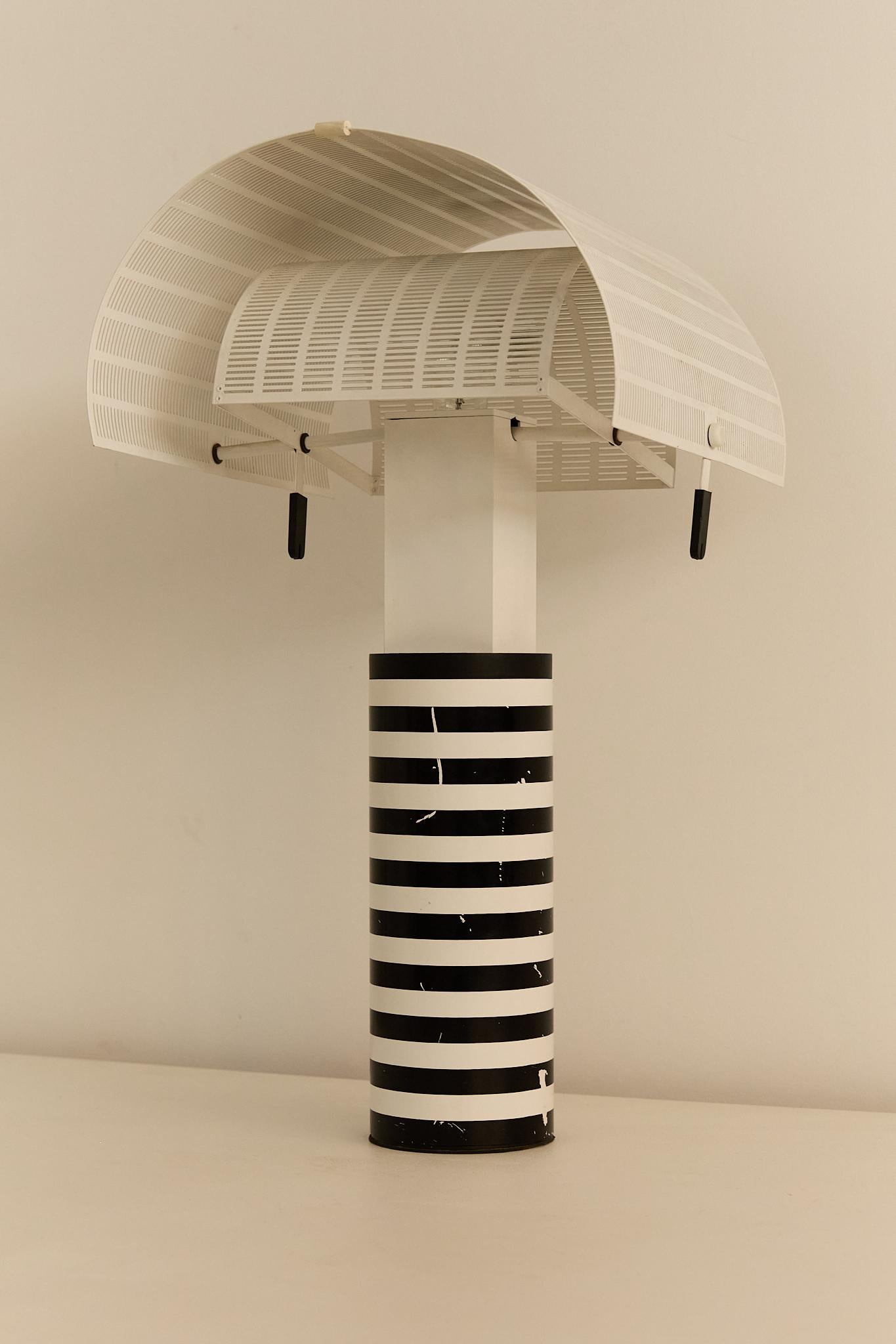 Mario Botta (nato nel 1943) per Artemide, lampada da tavolo Shogun. Base a righe bianche e nere con paralume traforato stilizzato. Segnato sulla parte superiore della colonna. Provenienza: Collezione del professor John Chambers, Regno Unito.