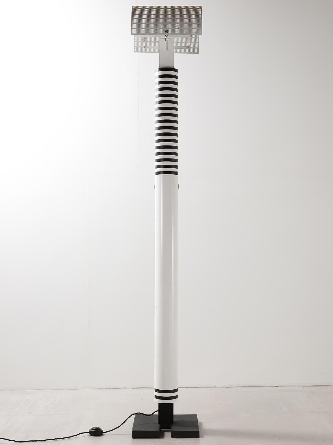 This Shogun floor lamp, designed in the 1980s by Mario Botta for Artemide, stands at 210cm tall on a solid black cast iron base, with a powder coated black and white striped shaft which supports two adjustable perforated metal diffusers.