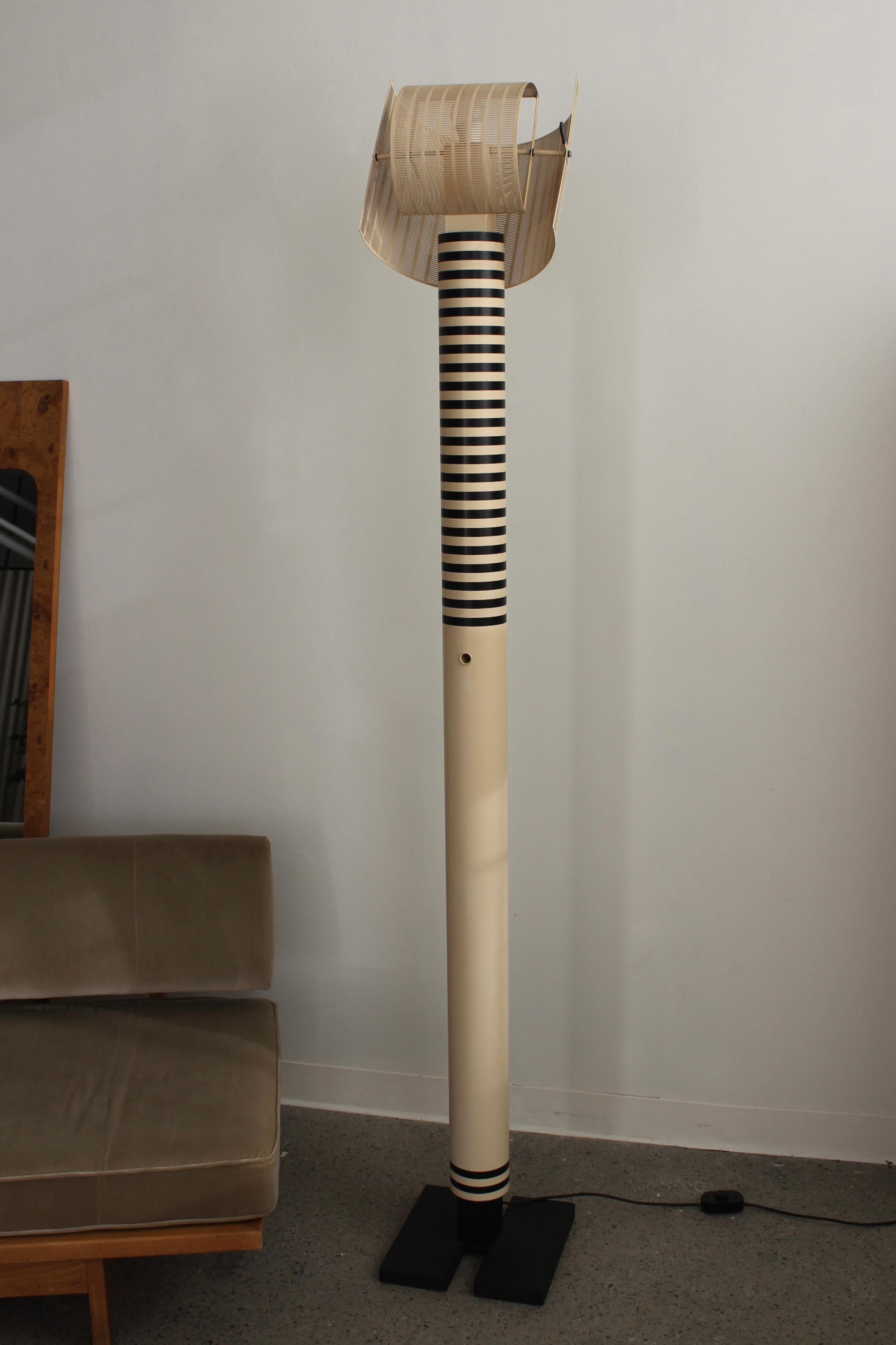 Shogun Terra Floor Lamp by Mario Botta for Artemide, 1980s. Cast iron base, cream coloured steel shaft with black stripes. Two curved perforated shades can be adjusted to create a variation of light partition.

In good condition, two markings on