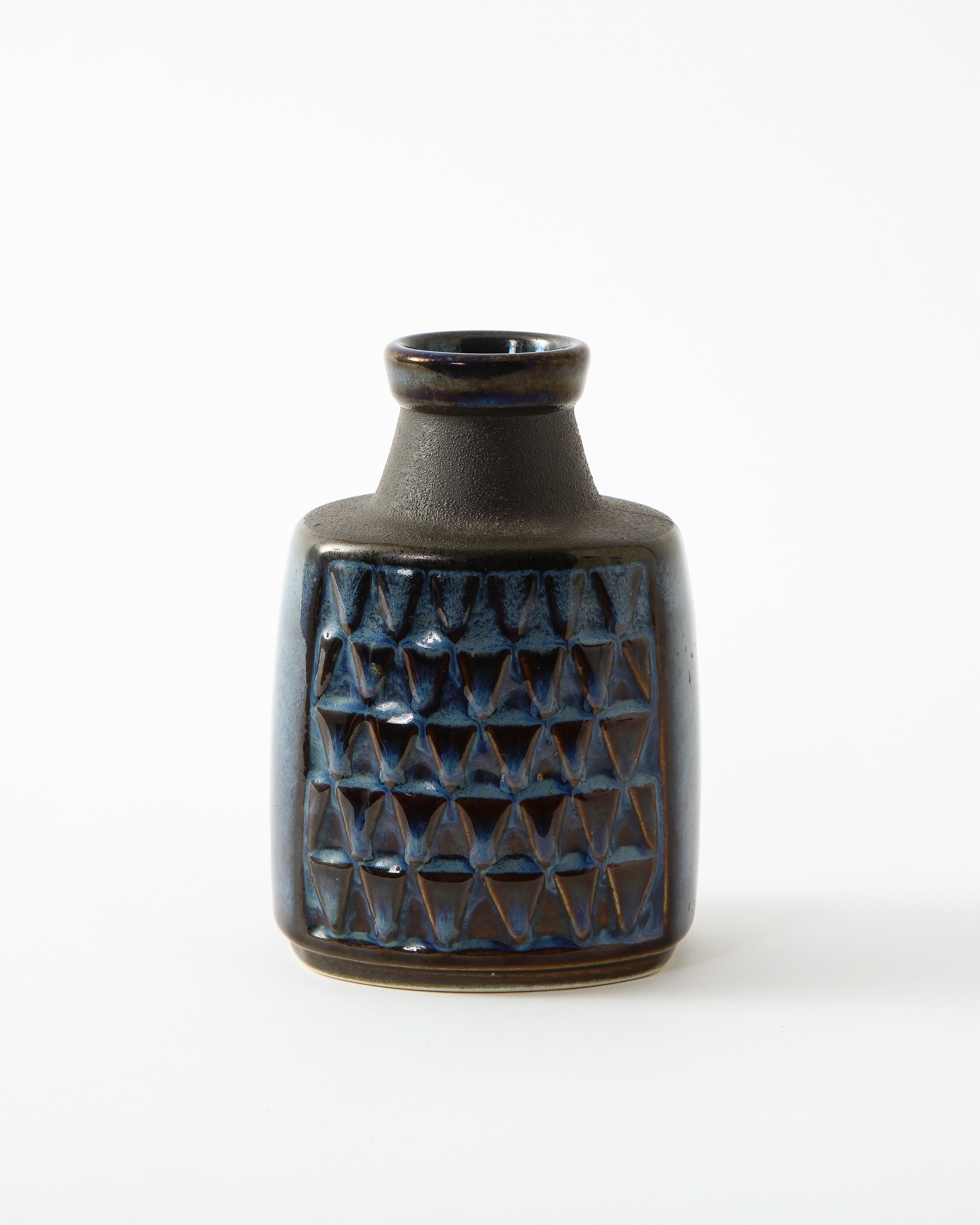 Elegant black ceramic vase in handsome deep blue glaze. Pressed triangular pattern on interior. Highlights and lowlights of glaze are characteristic of this style of pottery. Marked and numbered Søholm, Denmark. Bottleneck opening.